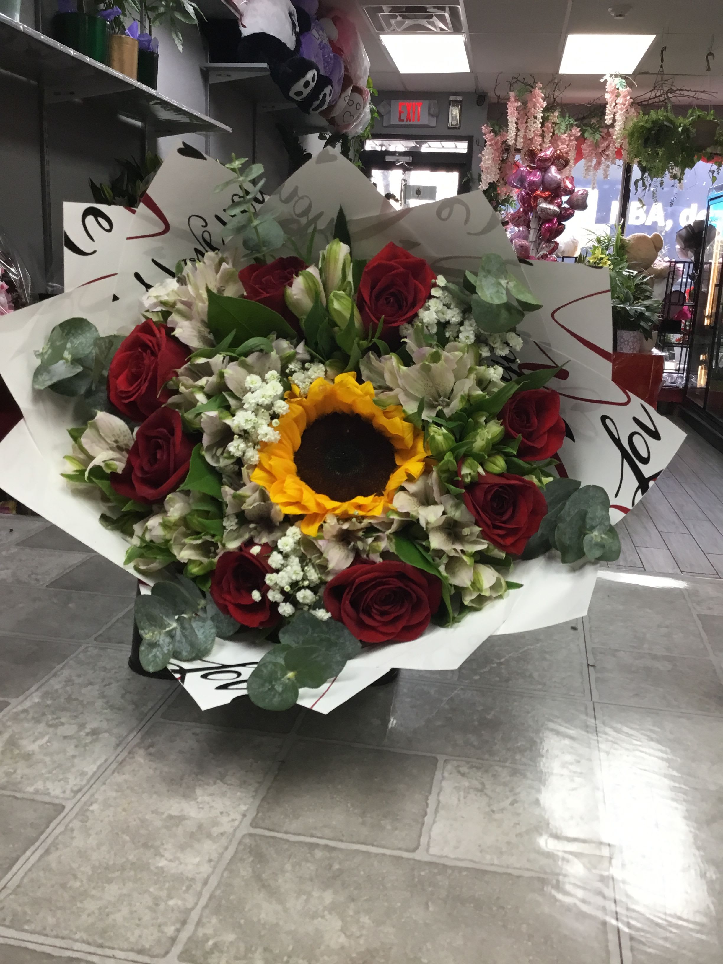 Bouquet of red roses and a sunflower with white flowers
