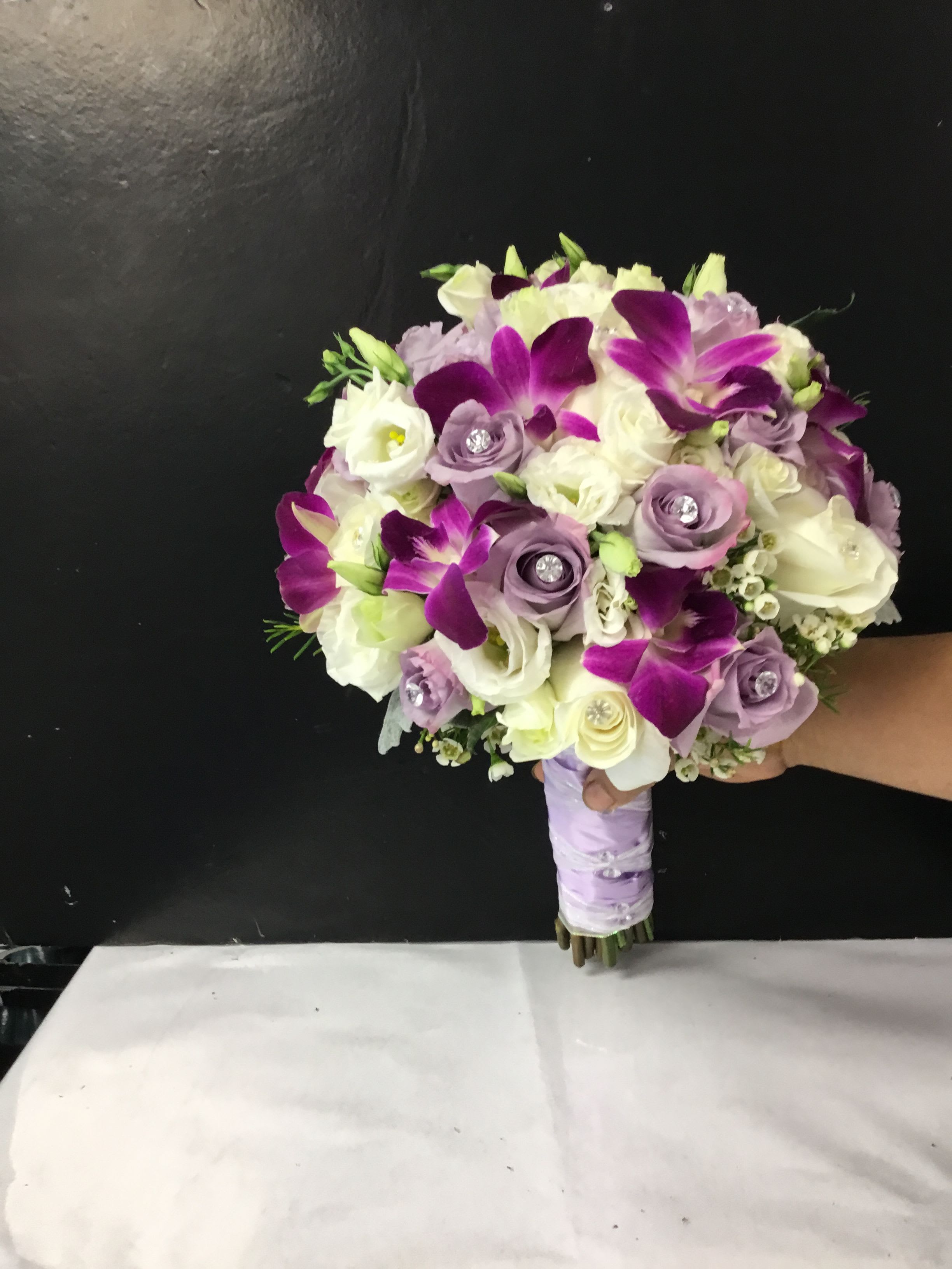 Purple and white bridal bouquet with roses and orchids