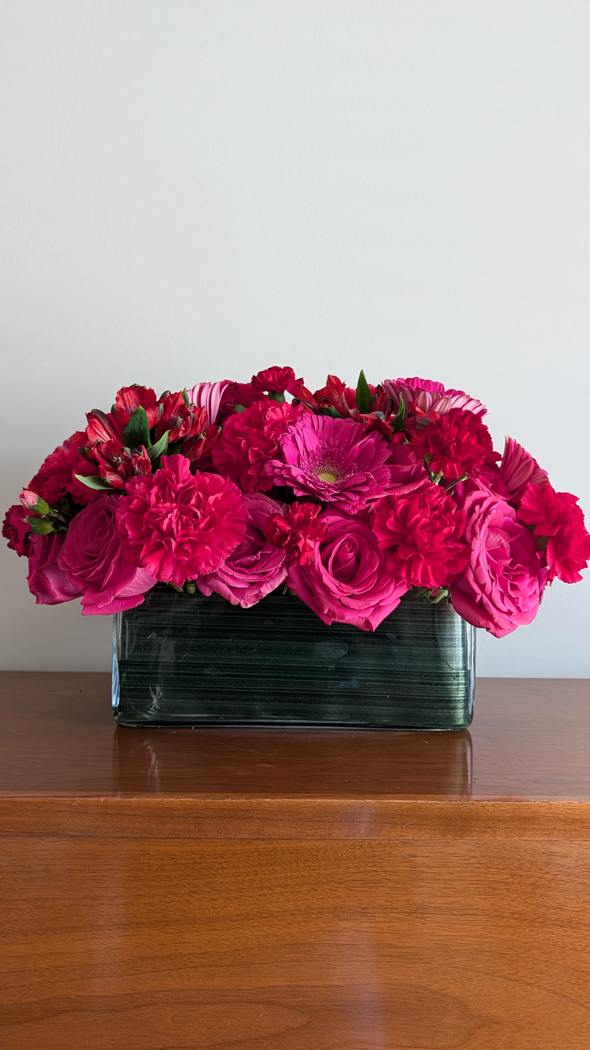 Pink and red mixed bouquet in a rectangular glass vase