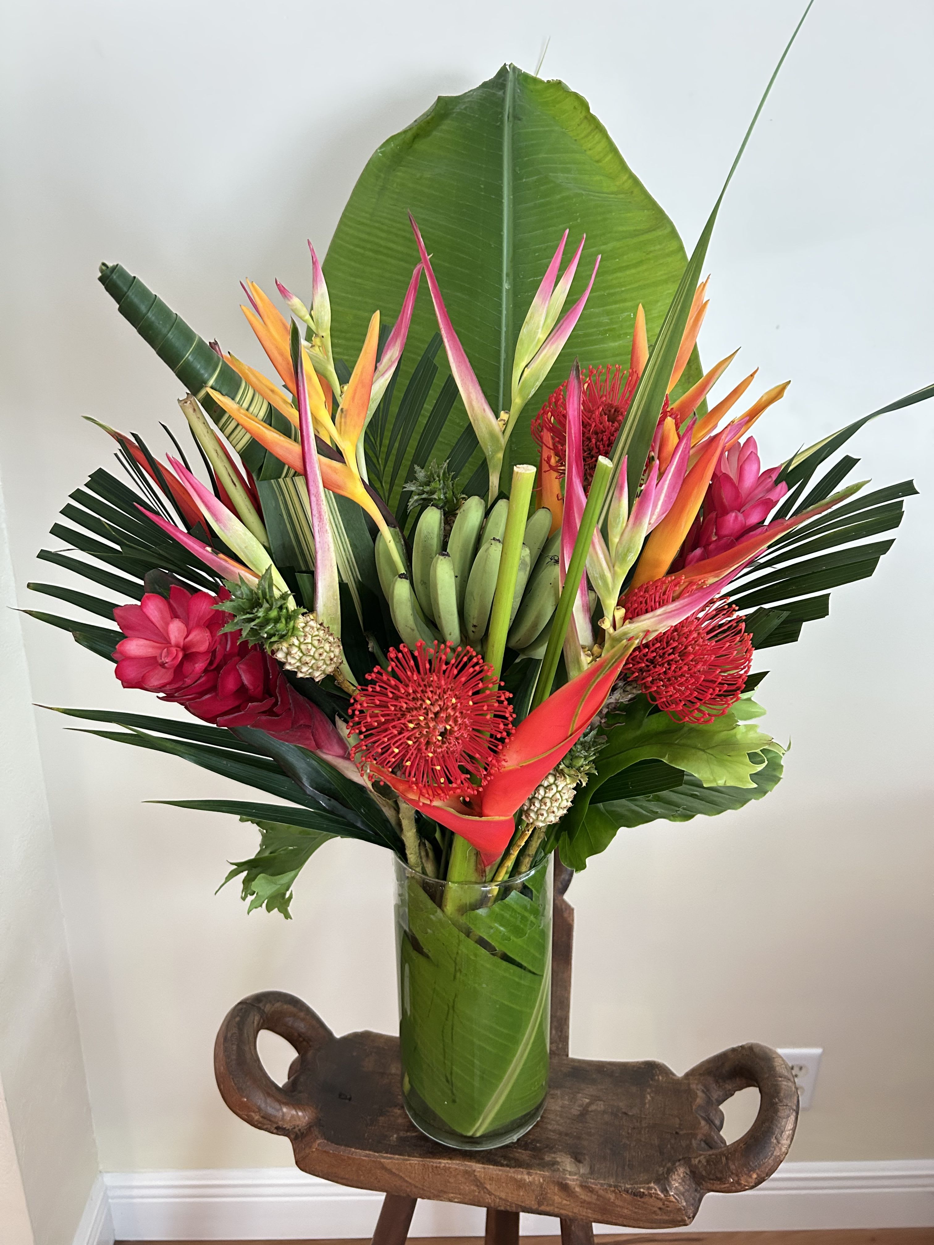 Tropical Splash - Splashing tropical display, Bold ad bright. Mix of tropical flowers and foliage. Bananas are not always available, we will notify if replacement will be used.