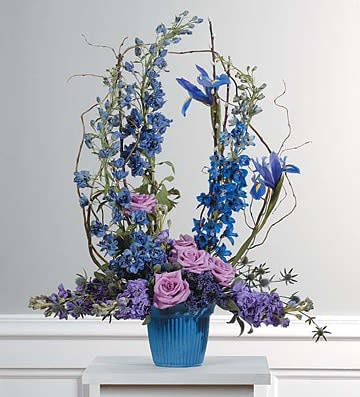 Blue and purple floral arrangement in a blue vase