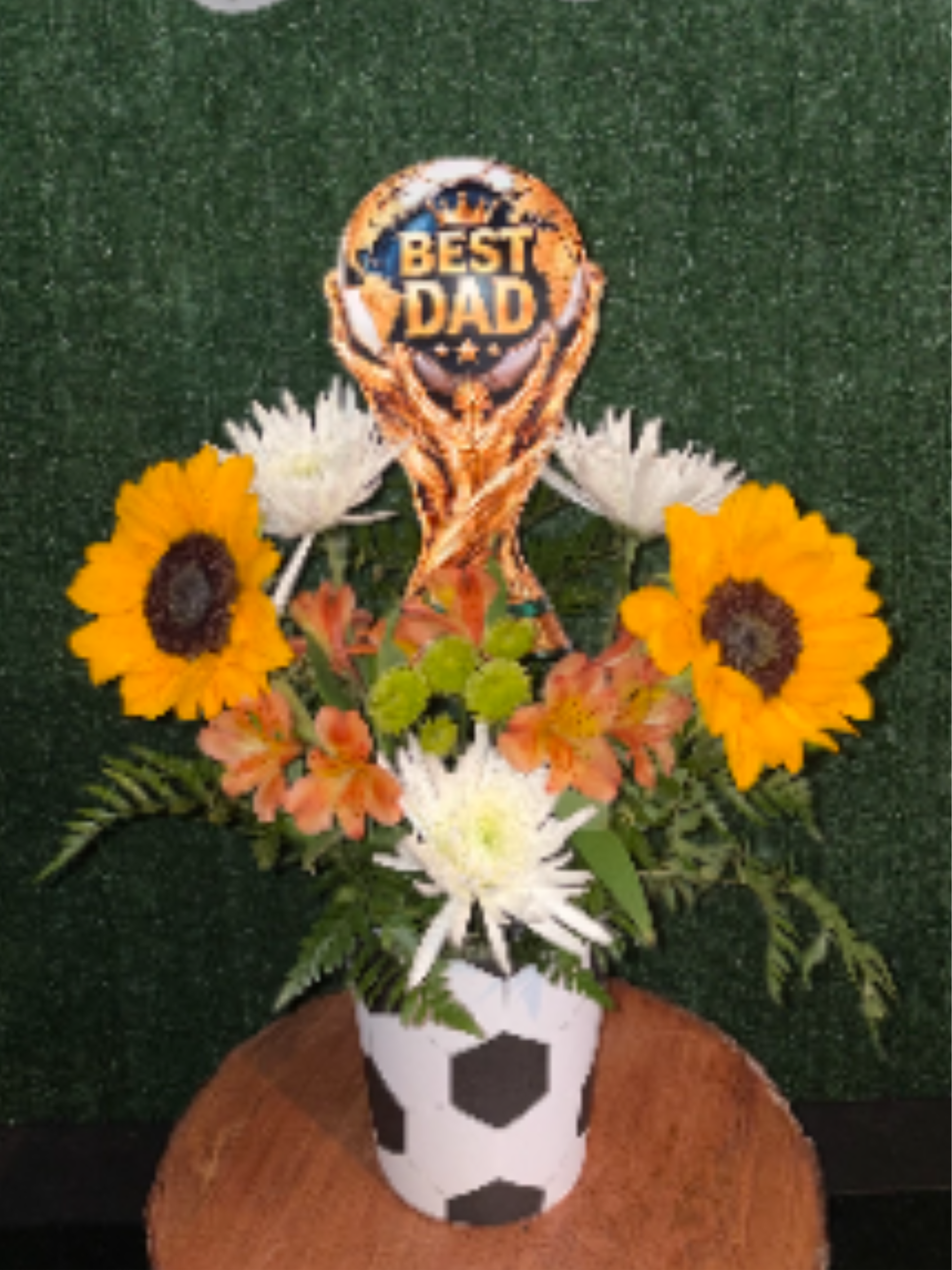 Sunflower and white daisy arrangement in a soccer-themed vase with a Best Dad topper