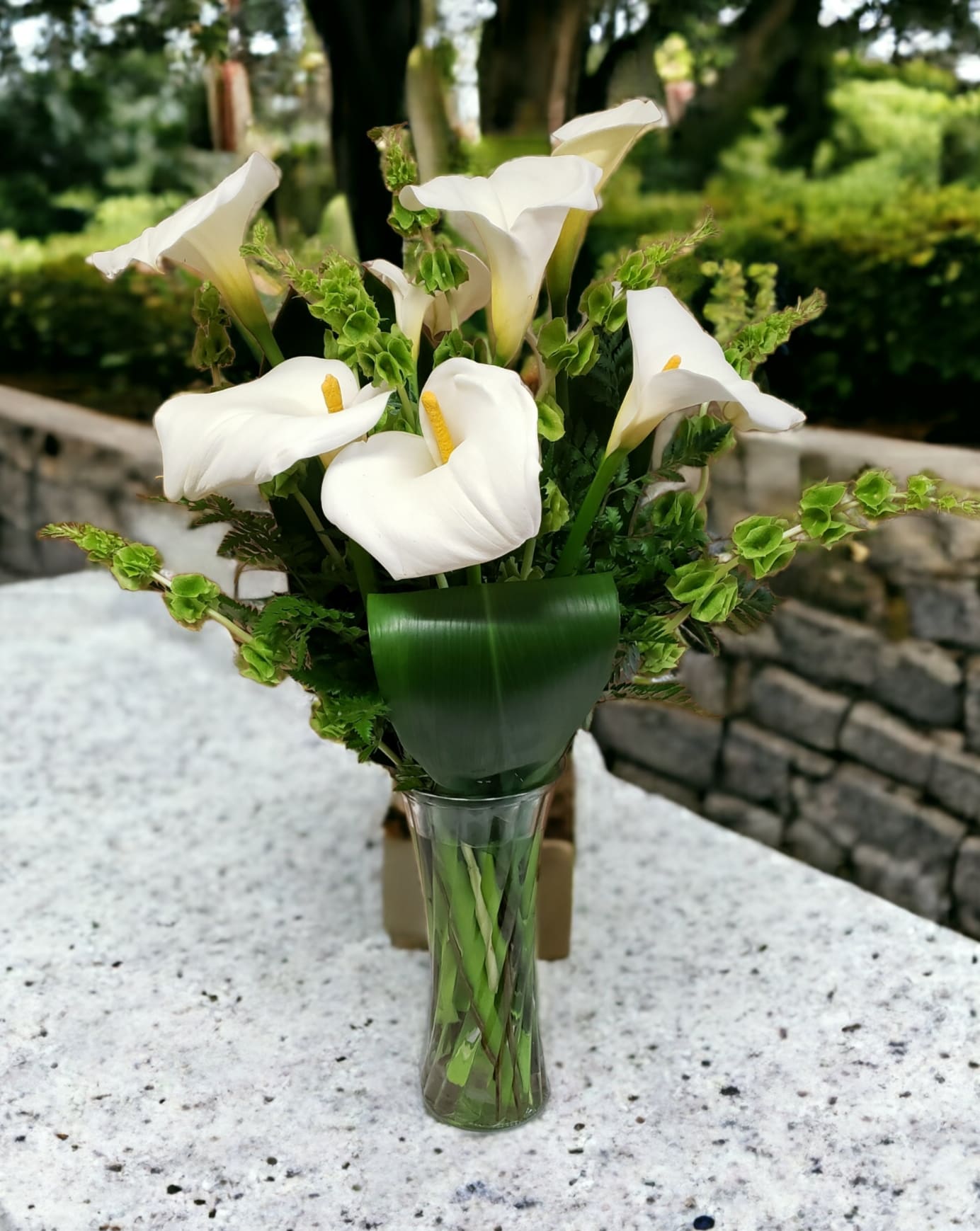 White calla lilies arranged in a clear glass vase