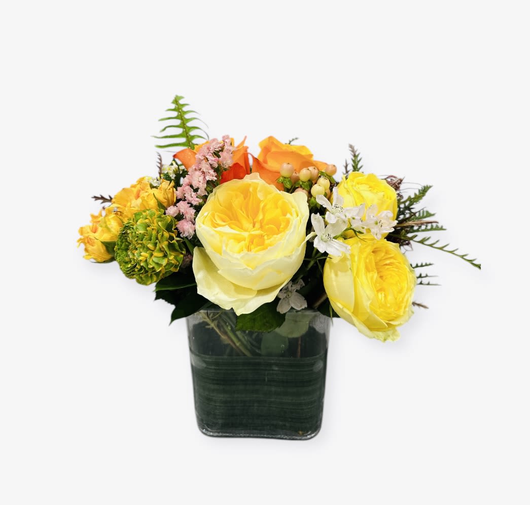 Yellow and orange rose arrangement in a square glass vase