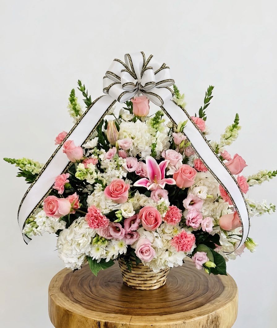 Sympathy basket 5 -  A large and comforting sympathy flower basket arranged in a traditional woven basket. This beautiful tribute features premium pink roses, pink lilies, carnations, and elegant white hydrangeas,  it brings peace and comfort to any memorial service.