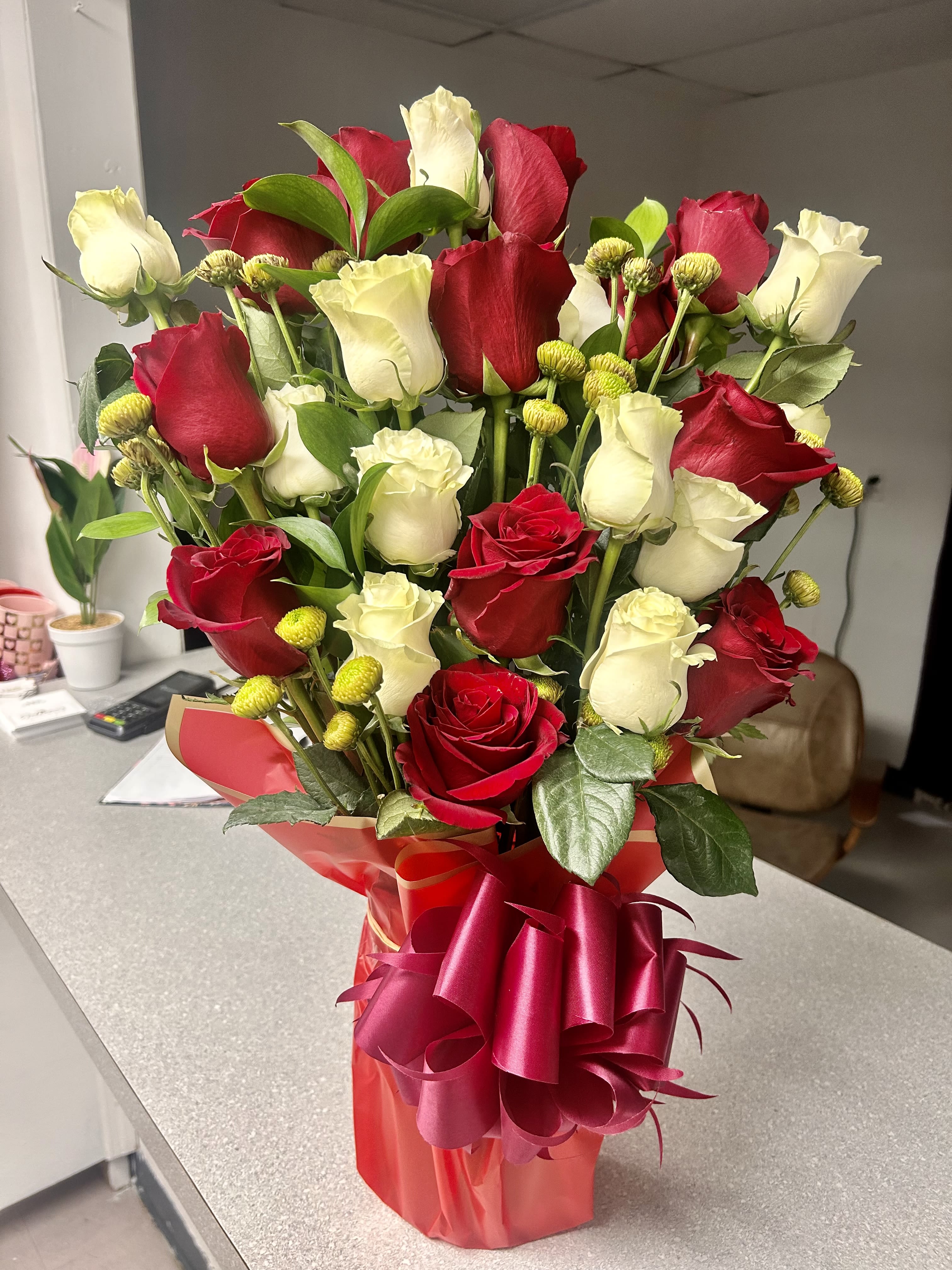 Bouquet of red and white roses in a red gift wrap with ribbon