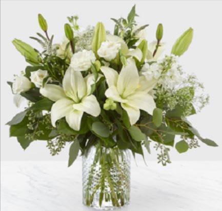 White lilies and roses in a clear glass vase