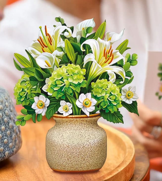 Ivory and Sage Mini Bouquet Greeting Card by Fresh Cut Paper - Measures 5.5” high by 5” across Printed on both sides An elegant and mini bouquet for all of life’s big moments, the Mini Ivory Sage Bouquet features crisp, white lilies and calla lilies, alongside sweet anemones, green hydrangeas, and eucalyptus branches centered in a naturalistic stone and wood vase. This mini arrangement sends big sentiments of comfort, kindness, and love in a small silhouette. The perfect bedside pick-me-up and an extra-thoughtful way to say you’re in my heart and on my mind. 