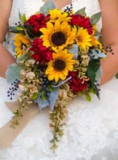 Sunflower Cascade Wedding Bouquet - Made to make the person you love feel joyous and seen, this bouquet suits outdoor ceremonies, barn venues, and autumn receptions where warmth and color are everything. Care is simple: keep stems in water until just before the ceremony and store in a cool place to preserve freshness; orders can be tailored for ceremony timing to ensure blooms arrive at peak color.