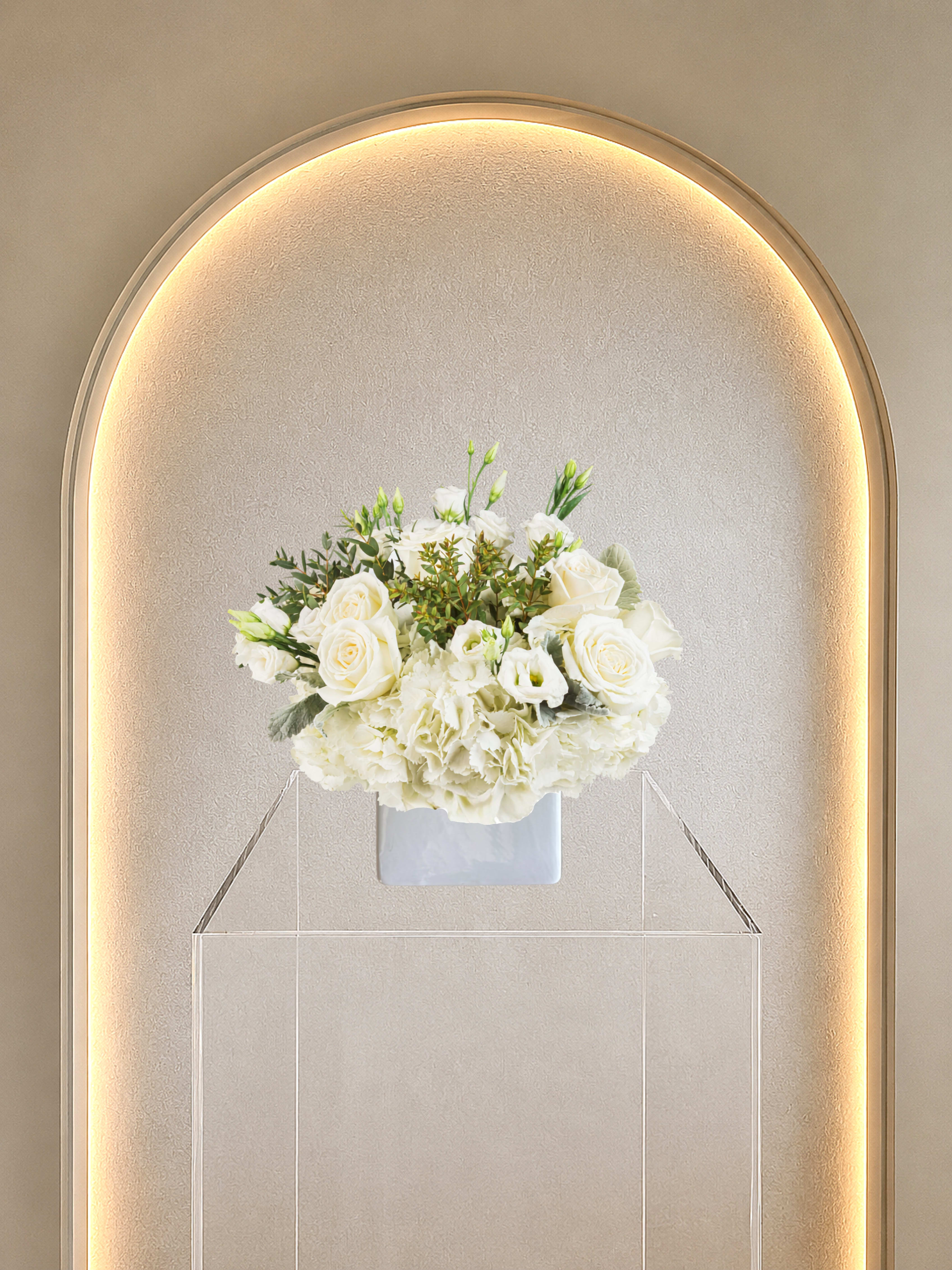In The Clouds - A cloud of white roses, hydrangeas &amp; lisianthus in a clear vase with soft green foliage, an airy annd elegant arrangement.  