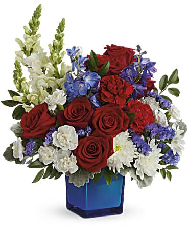 Red roses, white daisies, and blue flowers in a blue glass vase