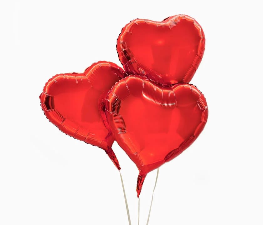 Three red heart-shaped balloons on sticks