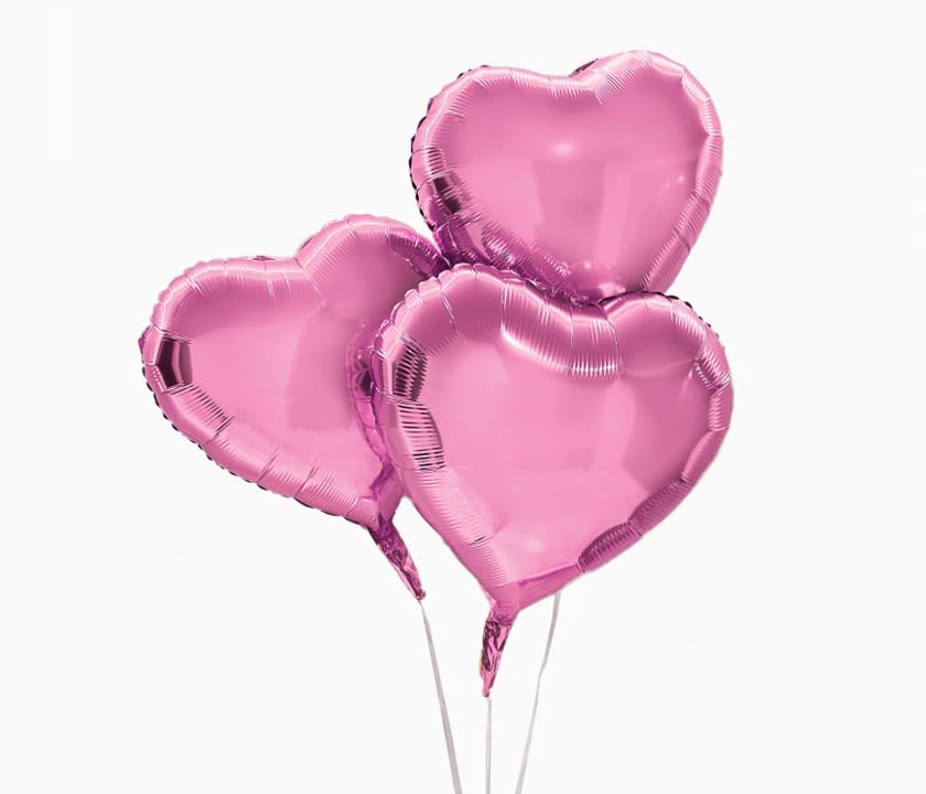 Three pink heart-shaped balloons on sticks