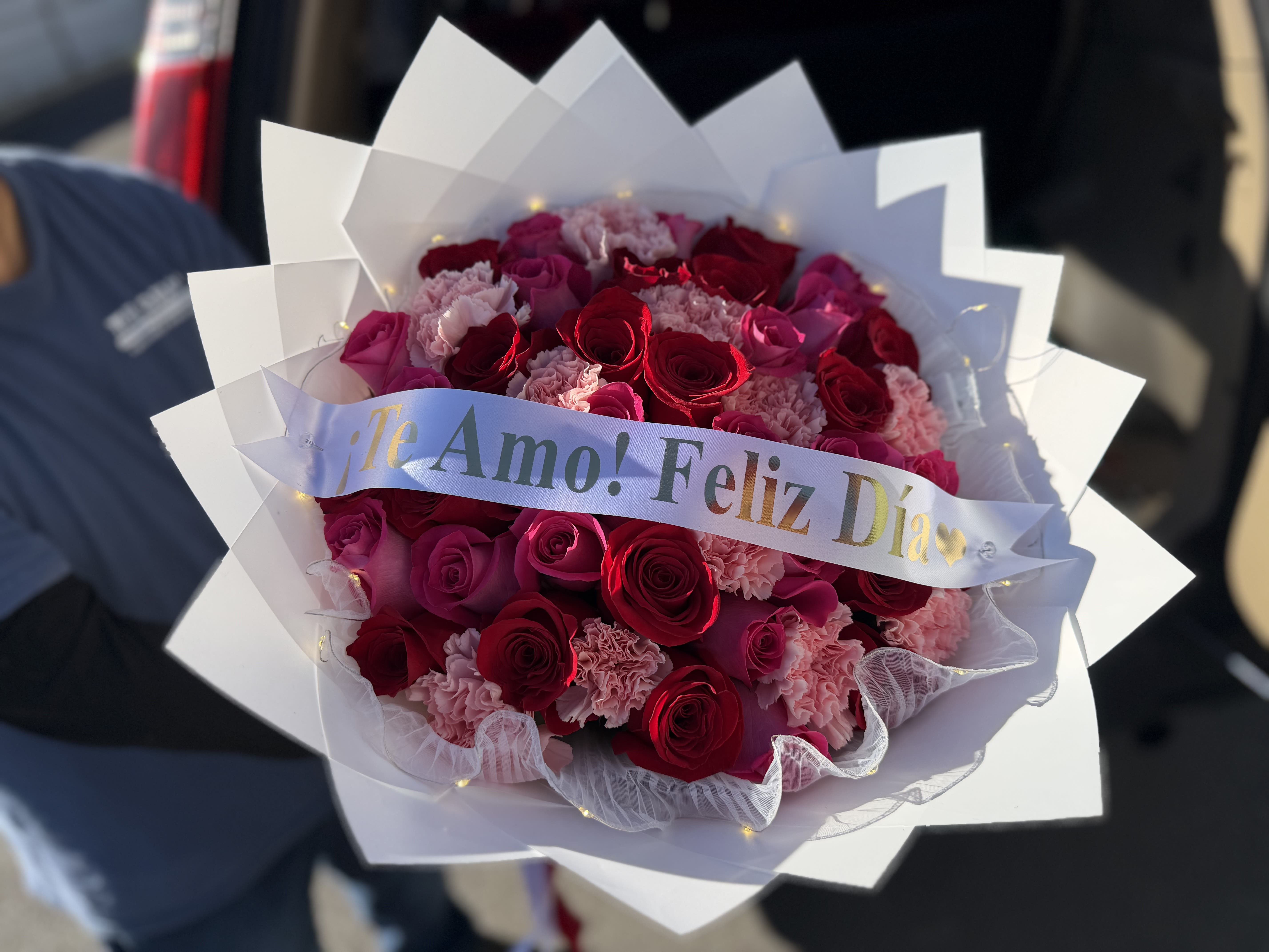 Bouquet of red roses and pink carnations with a "Te Amo! Feliz Día" ribbon