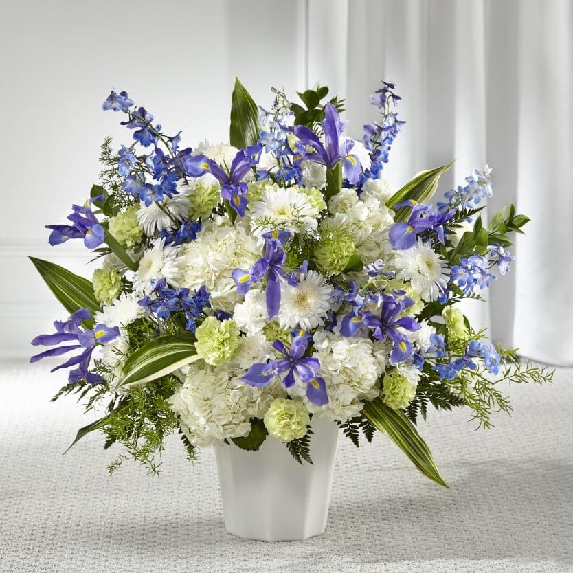White and purple floral arrangement in a white vase