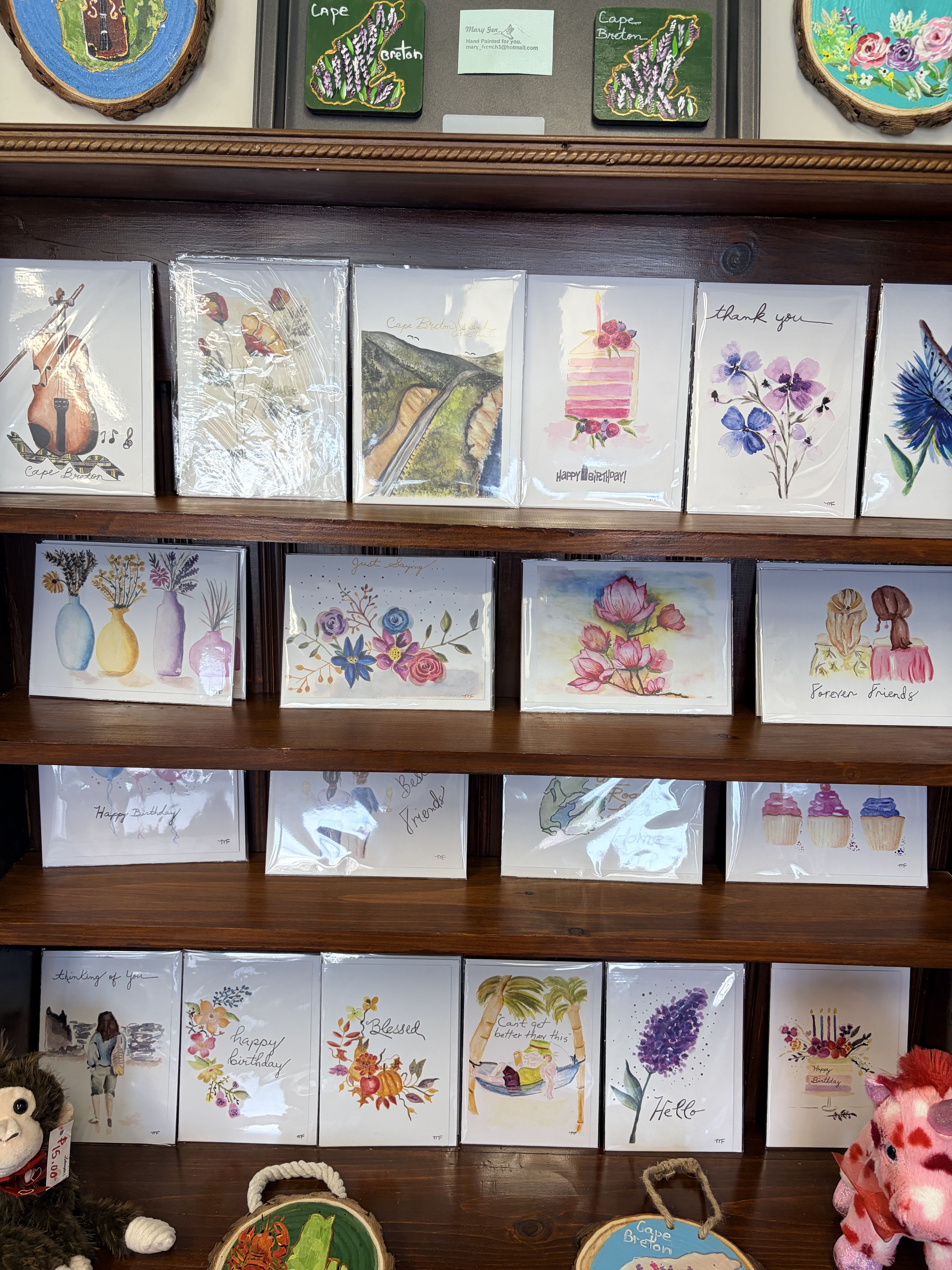 Display shelf of watercolor greeting cards with floral designs and birthday messages