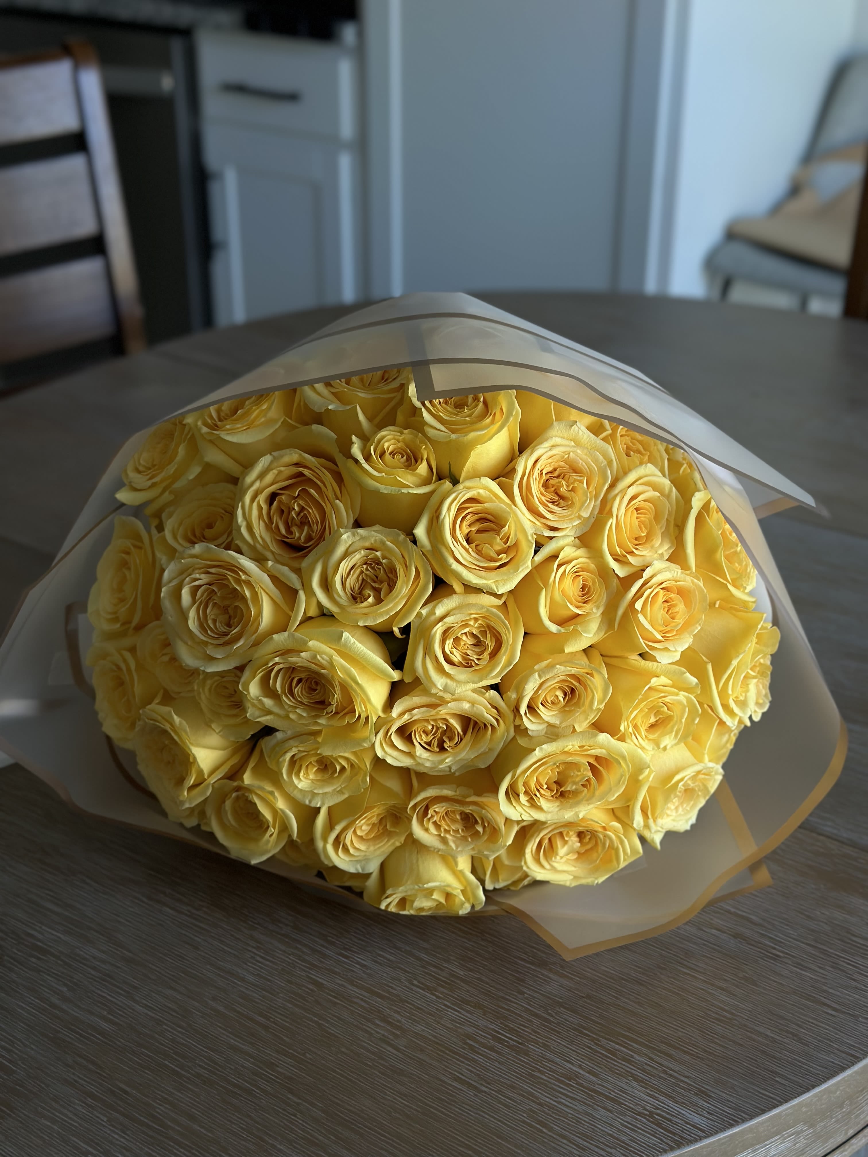 Bouquet of yellow roses wrapped in white paper