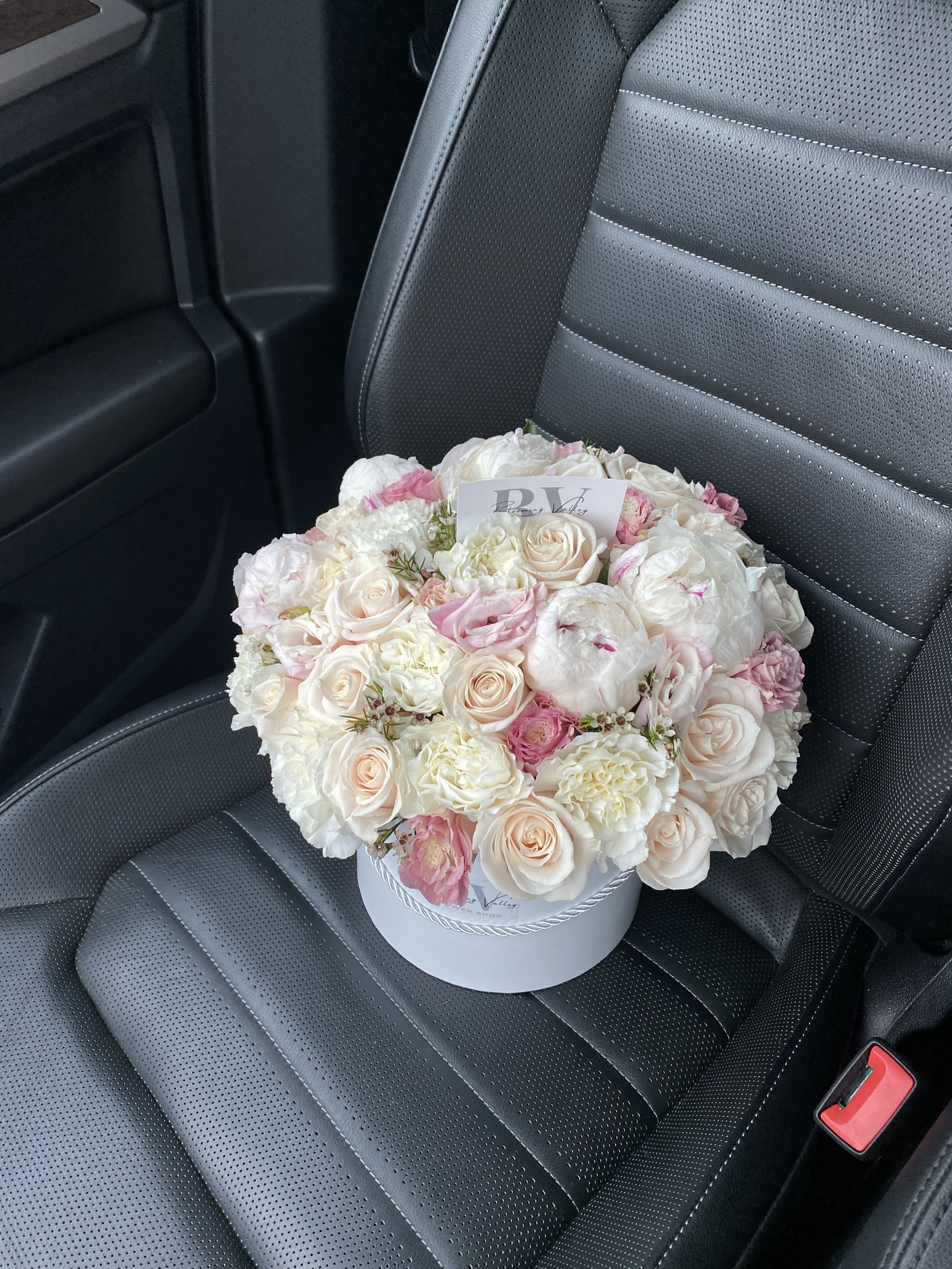 Sweet Symphony - Elegantly arranged in a pristine white hat box, Sweet Symphony is a luxurious blend of creamy roses, soft pink ranunculus, and lush peonies. Each bloom is hand-selected to create a round, harmonious composition that radiates tenderness and sophistication. Ideal for romantic gestures, heartfelt celebrations, or simply to enchant someone’s day with beauty and grace.