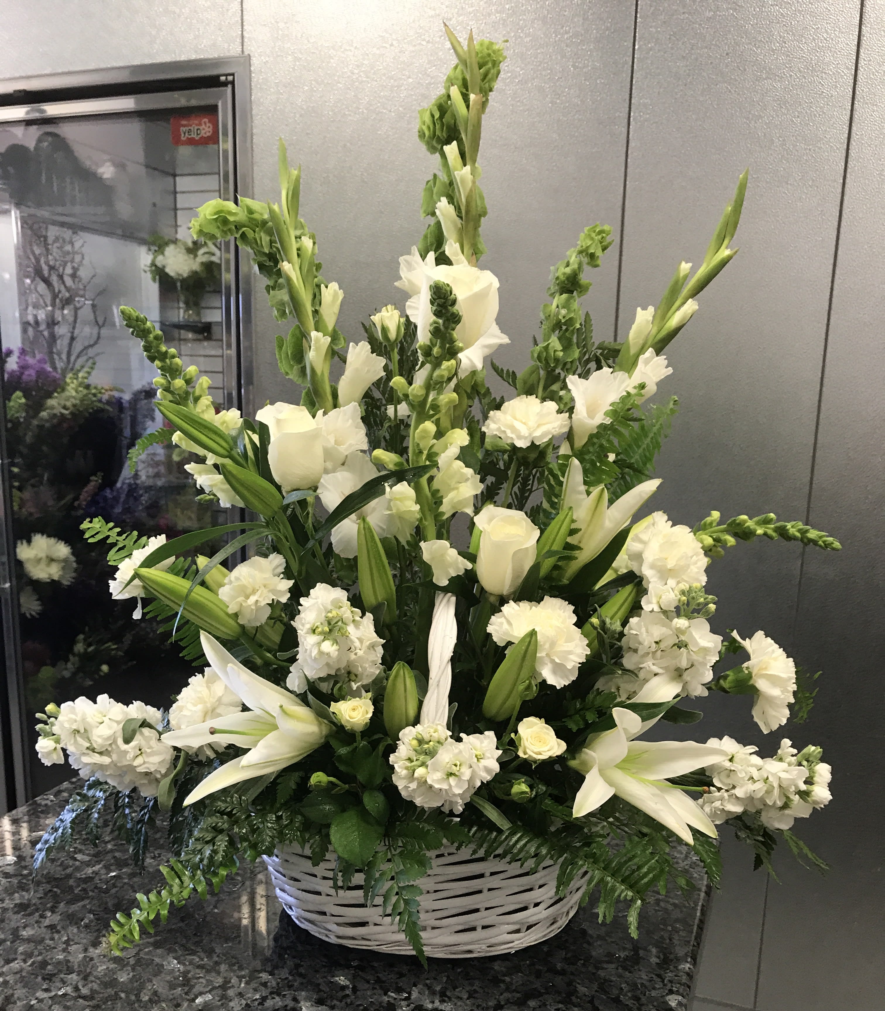 White floral arrangement in a white wicker basket