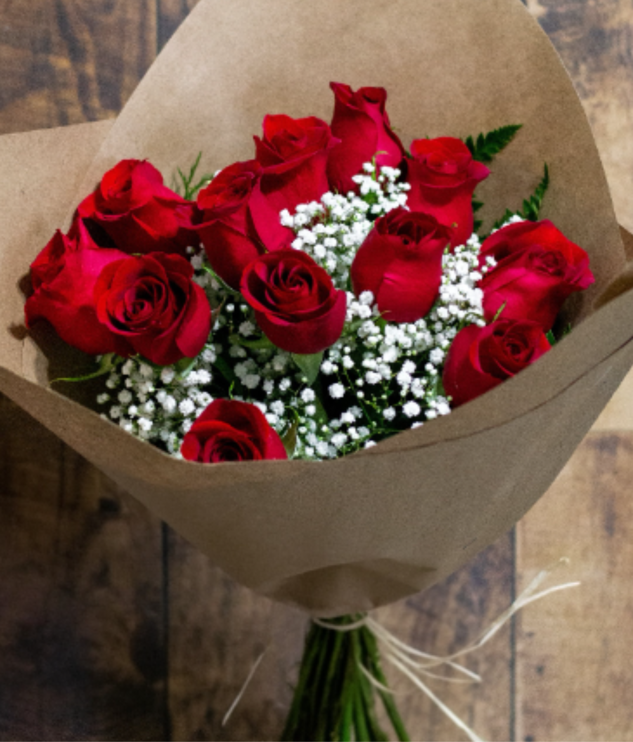 Bouquet of red roses with white baby's breath wrapped in brown paper