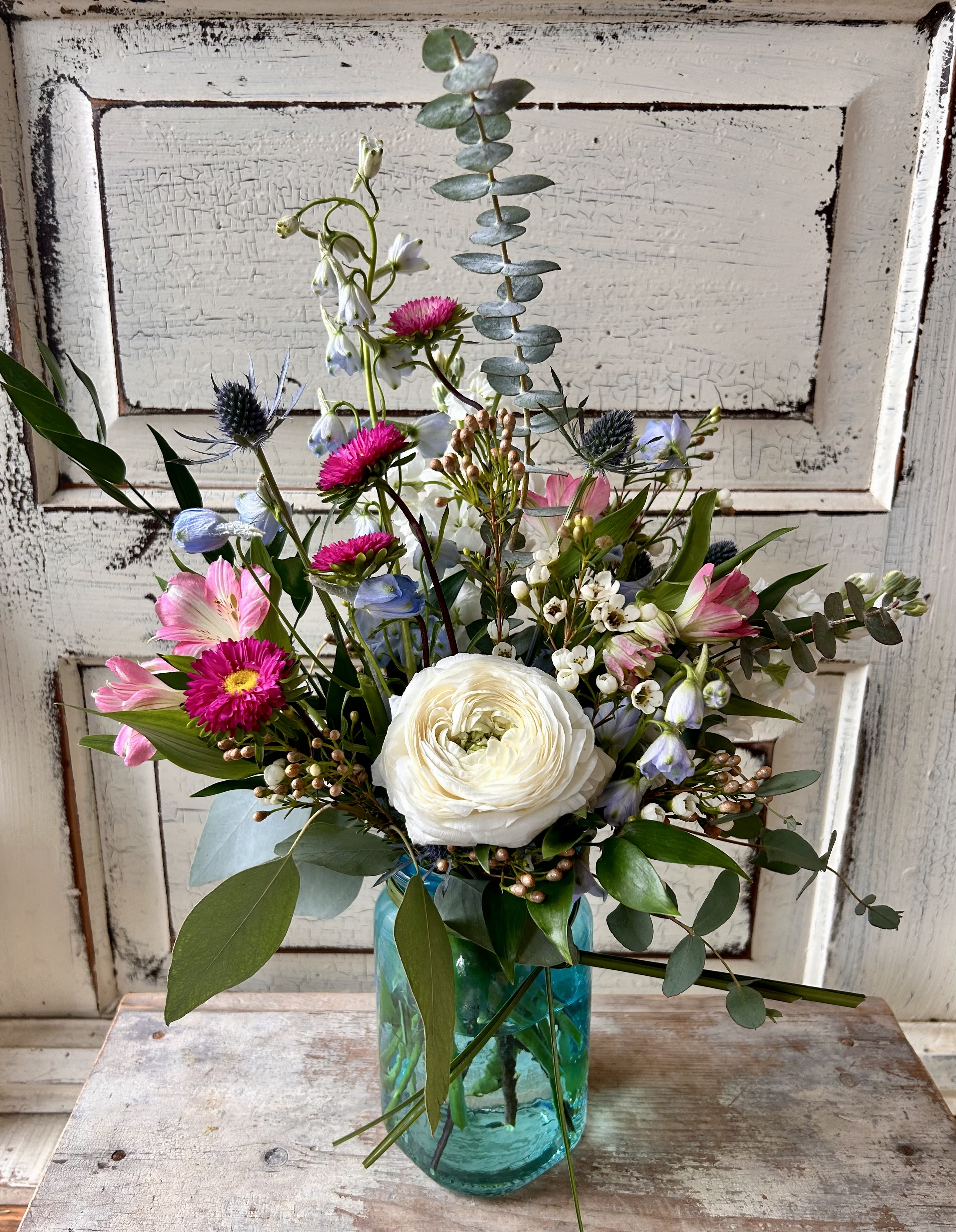 Meadow Bouquet - A small colored glass vase or jar holds a just right petite assortment of fresh flowers and foliage perfect for a small gift. Flower varieties and colors will vary from photo. Glass will come in pink, green, purple or blue.