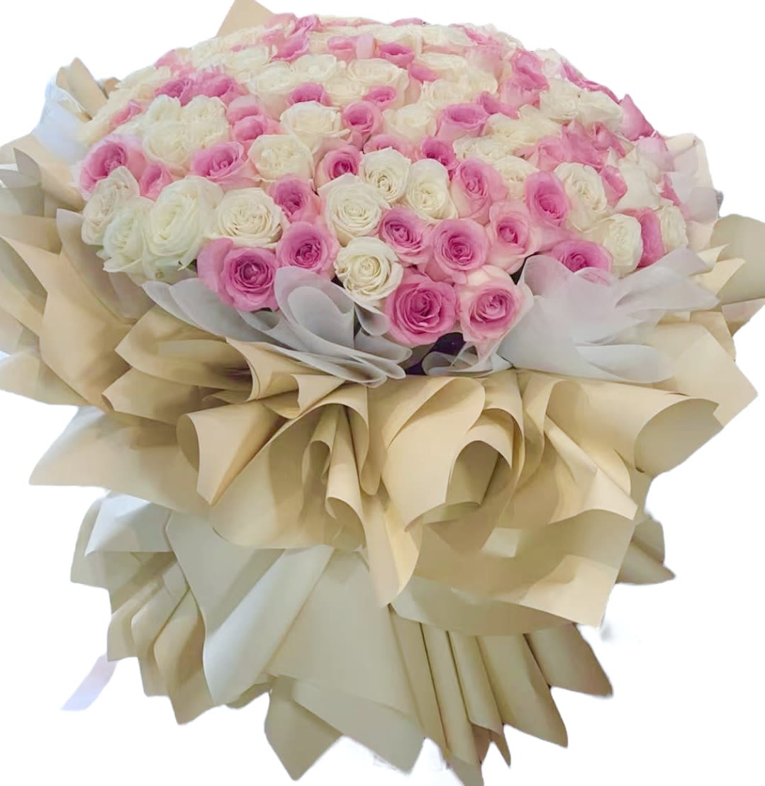 Large bouquet of pink and white roses wrapped in beige paper