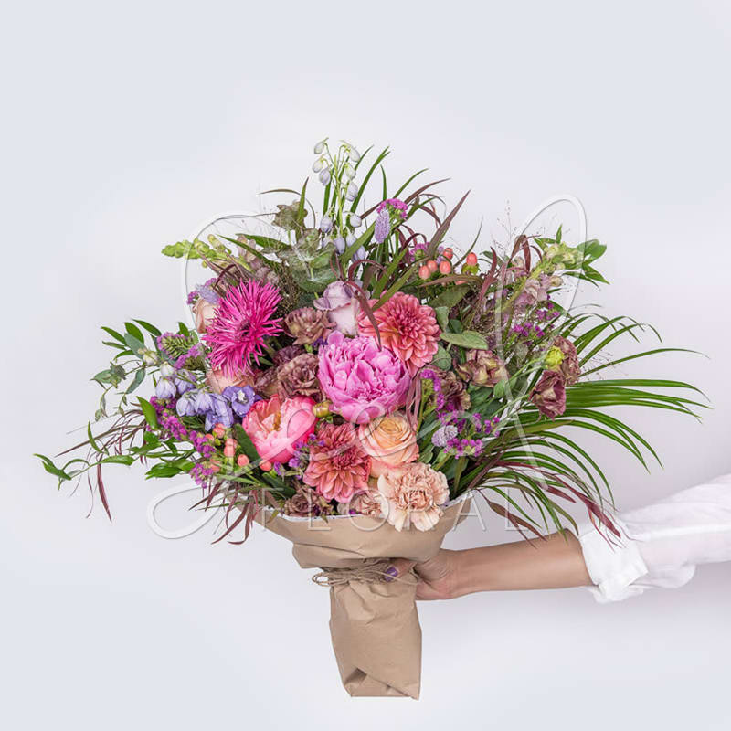 Seasonal Summer Bouquet - A lush, hand-tied summer bouquet that bursts with joyful color-perfect as an anniversary bouquet, birthday flowers, get-well, graduation gift that feels both celebratory and deeply personal. This Seasonal Summer Bouquet mixes pink peonies and bright gerbera daisies with peach roses and dahlias for an immediate, romantic impact; touches of lavender stock and delphinium add cool contrast so the recipient will feel truly seen and uplifted.  STANDARD: Bouquet DELUXE: Bouquet + Moonstruck Chocolate  PREMIUM: Bouquet + Moonstruck Chocolate + Candle
