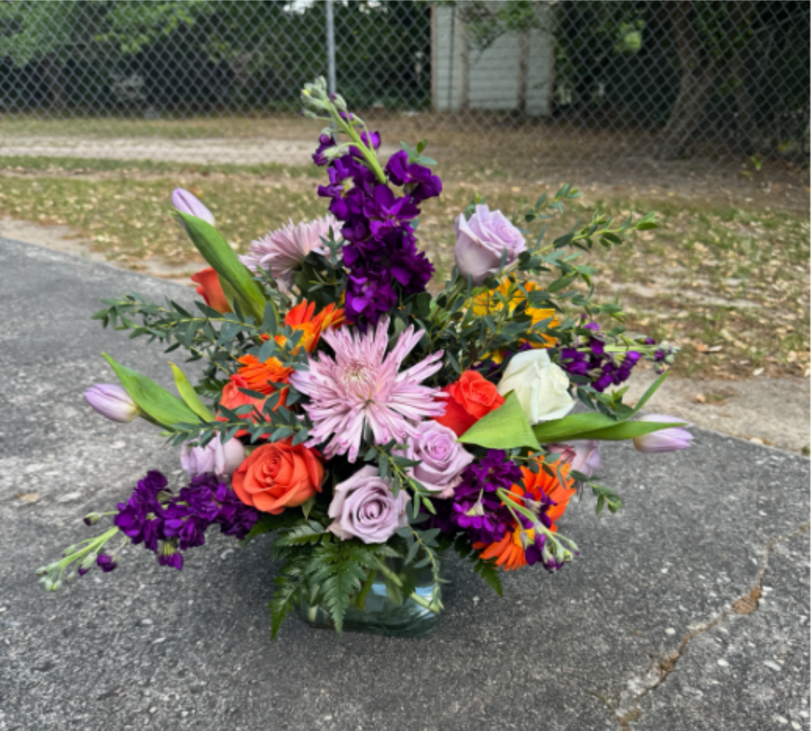 Mixed bouquet in a glass vase with purple, pink, orange, and white flowers