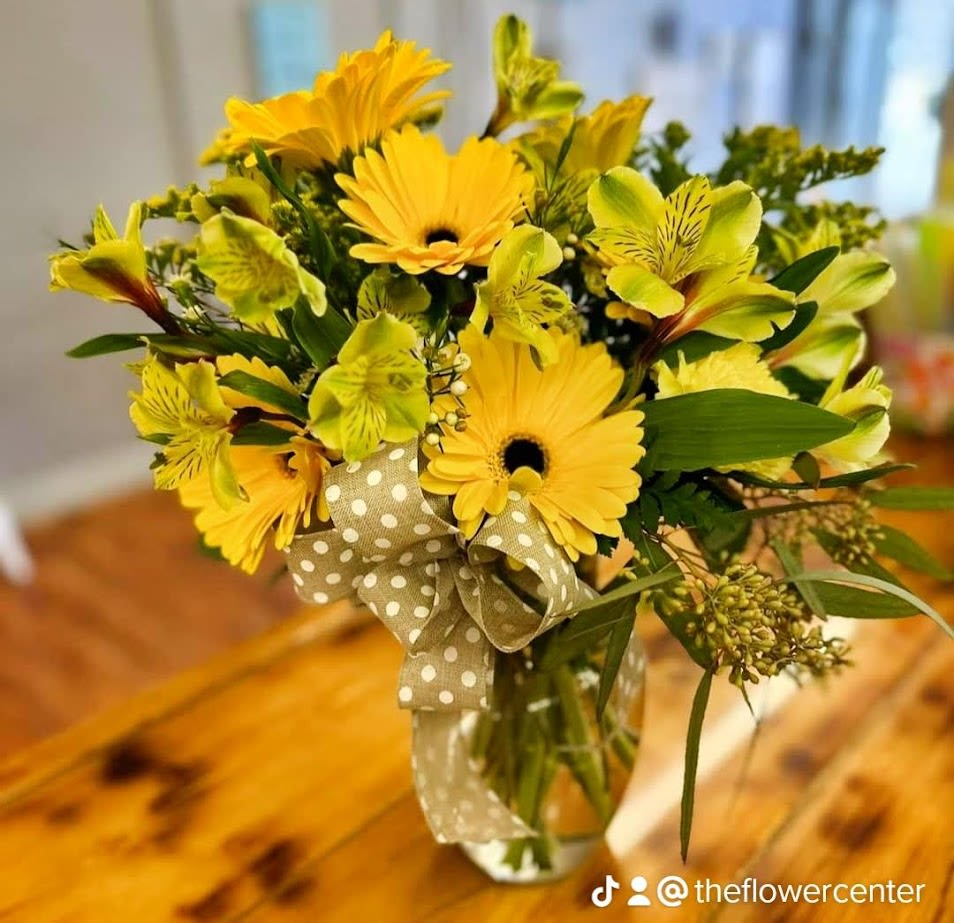Yellow gerbera bouquet with green alstroemeria in a glass vase