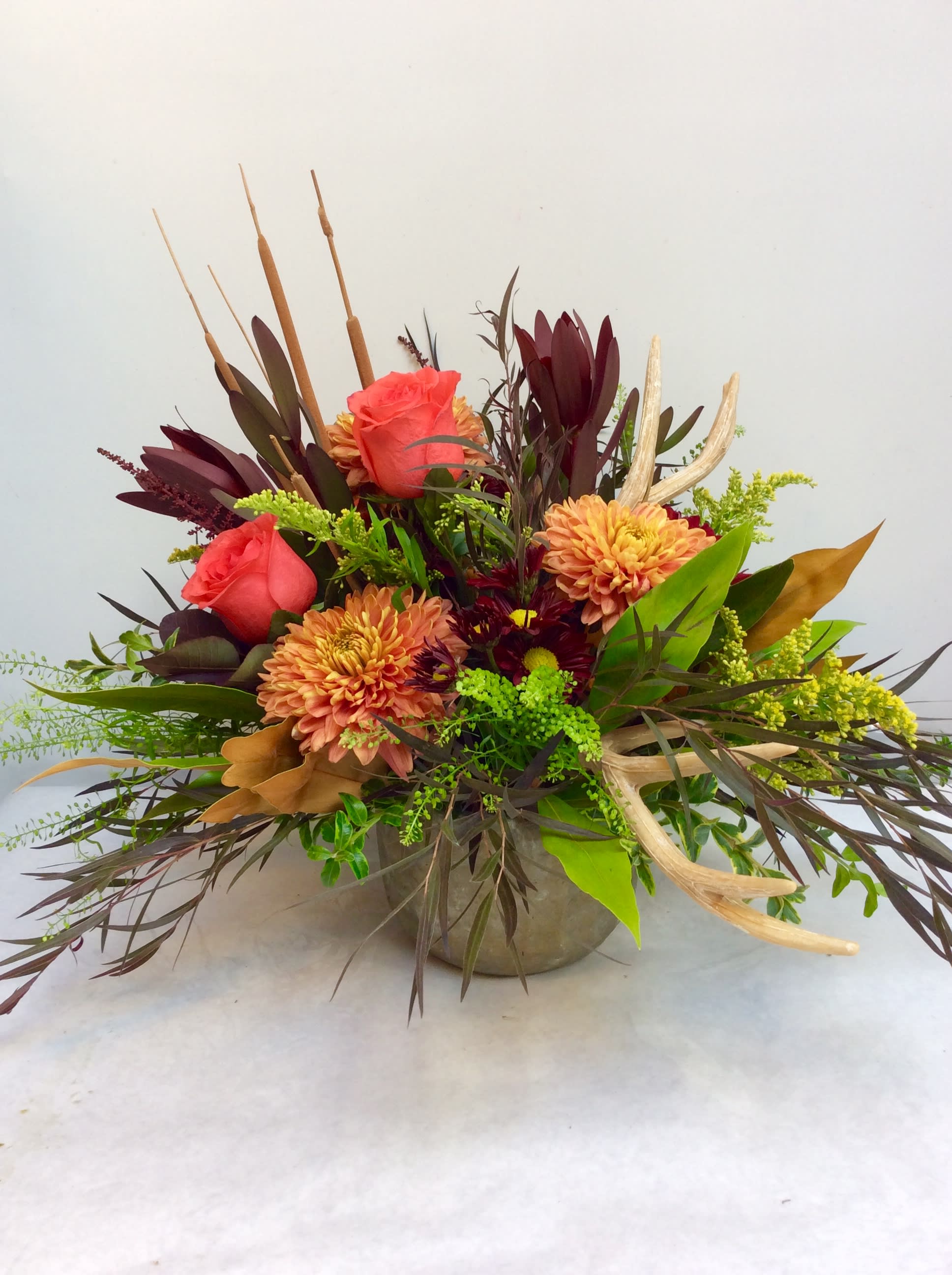 All that is Fall - Modern compote stuffed with fall favorites in bronze oranges and reds.The sutumnal textures are accented with antlers for a bountiful feel.