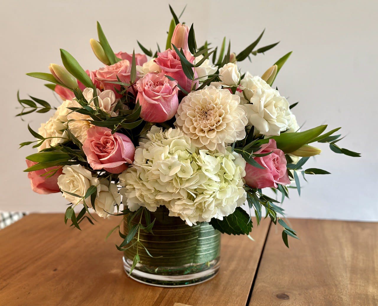 Pink roses and white hydrangeas arranged in a glass vase