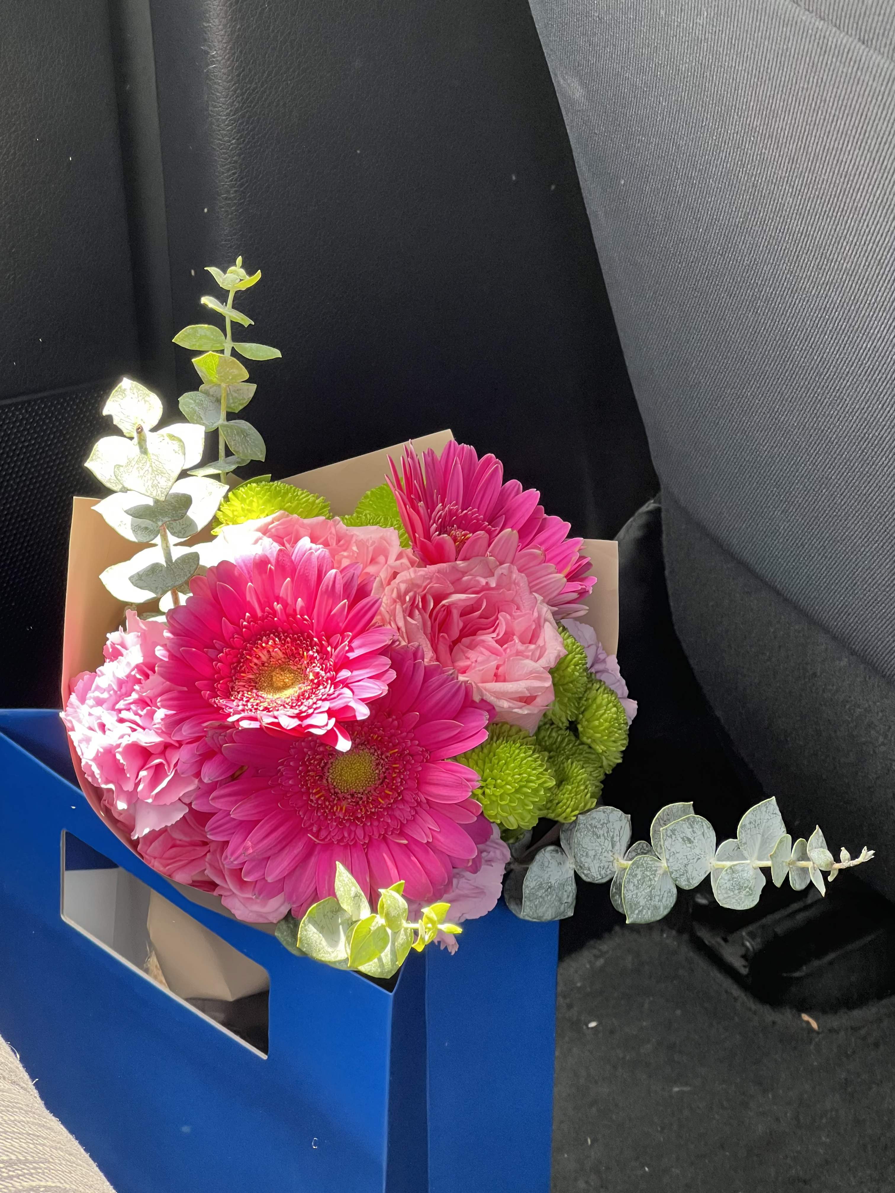 Happy Day Gift Box Bouquet - Bursting with color and energy, this cheerful gift box bouquet features bold hot pink gerbera daisies, soft pink carnations, lime green button mums, and delicate lavender blooms, all accented with fresh eucalyptus. Packaged in a charming gift box, it arrives ready to give — no wrapping needed. The perfect pick for birthdays, celebrations, get wells, or any moment that calls for a big, bright smile. Fun, fresh, and impossible to ignore.