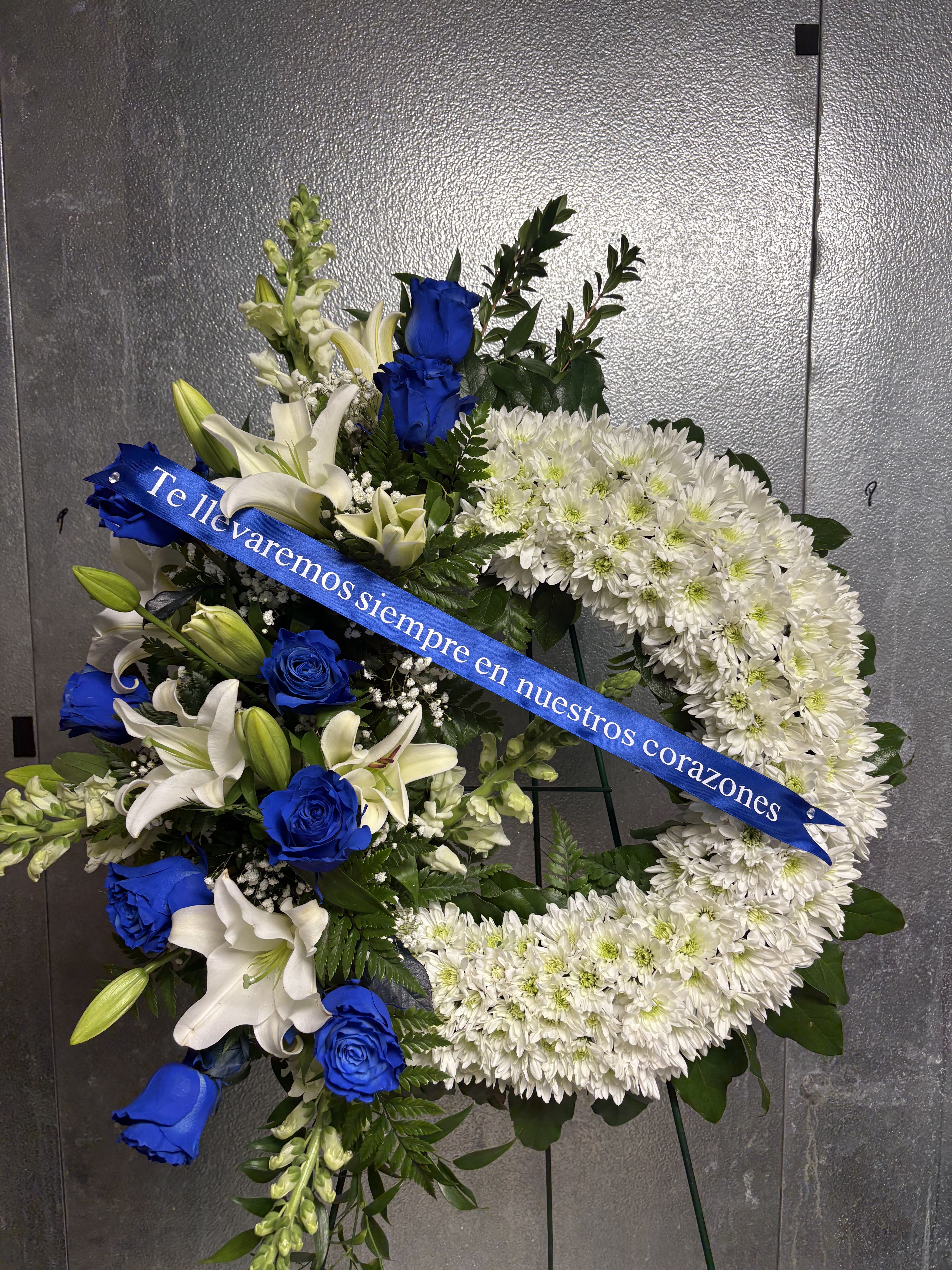 Blue funeral arrangement  - Funeral arrangement with blue roses on the side.