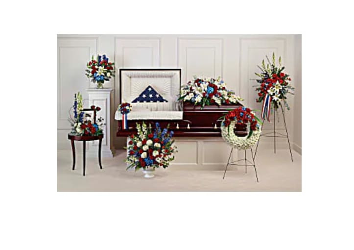 Funeral casket spray and wreaths in red, white, and blue