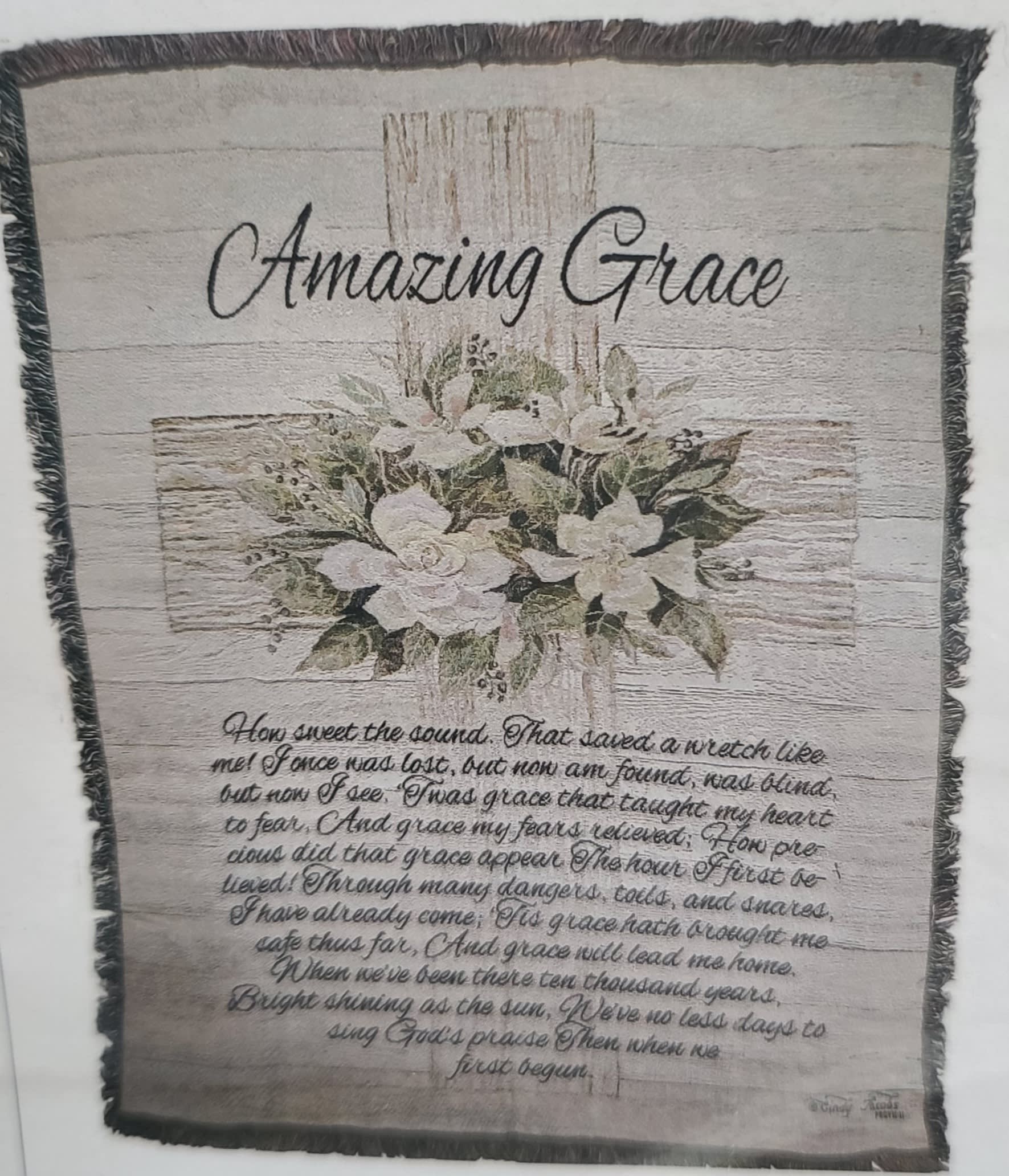 Framed wall hanging with white flowers and the words Amazing Grace