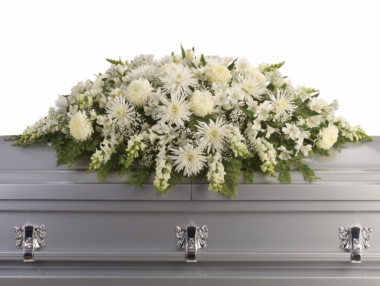 Enduring Light Casket Spray - A broad, low-profile white casket spray that conveys calm and reverence-perfect as a sympathy arrangement for a funeral or memorial service. This casket spray places layered white chrysanthemums and open lilies across a full, textured bed so the person you're honoring is remembered with quiet dignity and grace.  The arrangement combines large white chrysanthemum blooms, fragrant lilies, and clusters of alstroemeria to add delicate detail, all nestled into lush green foliage that frames the composition and softens the edges. Designed to lie flat across a casket, the piece has a wide, horizontal silhouette and a full, multi-layered look that reads clearly from the front and sides.  For families seeking a respectful tribute, this spray offers a timeless, formal presentation that helps loved ones feel comforted and honored. Standard sizing is intended for full casket coverage; please contact us to confirm dimensions or request personalization so we can ensure the spray fits the service and expresses exactly the sentiment you want to send.
