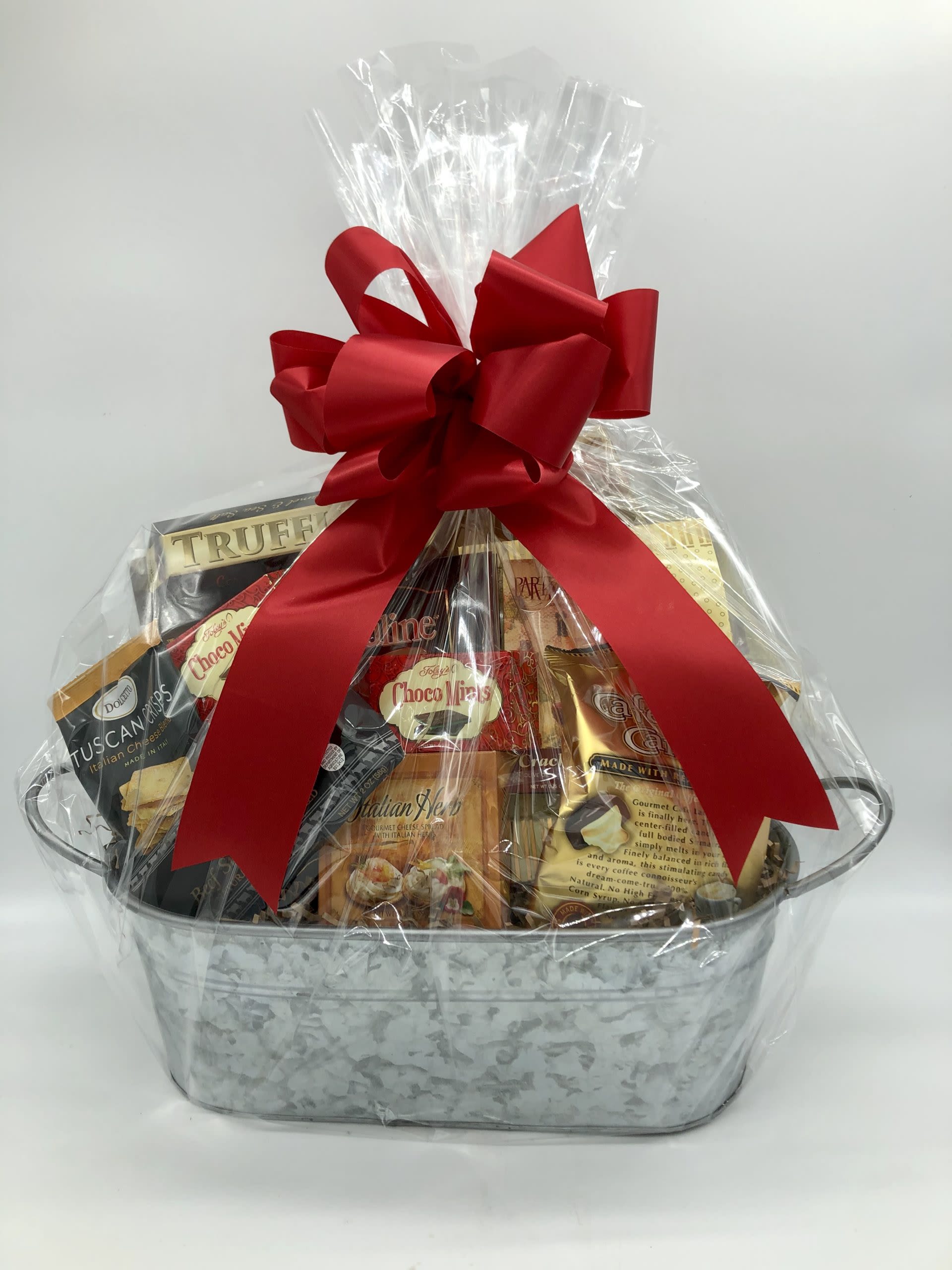 Gift basket of assorted snacks wrapped in clear cellophane with a red bow