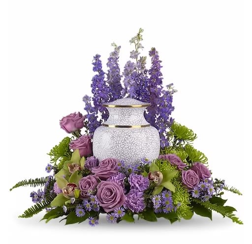 Meadows of Memories - As you come together to share your memories, these assorted purple flowers cradle the urn in a loving embrace. The soft greens and soothing purples are ideal to grace a memorial service.