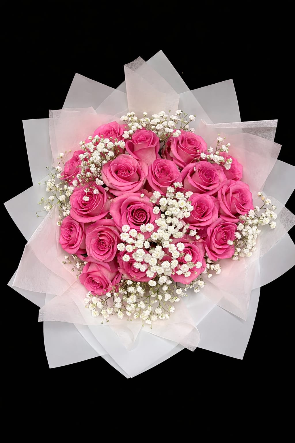 Bouquet of bright pink roses with white baby's breath in pale wrapping