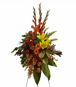Tropical Tribute Spray - A graceful modern funeral spray of warm colors, it includes flowers such as anthuriums, roses and tropical greenery. Presented as a standing easel display.