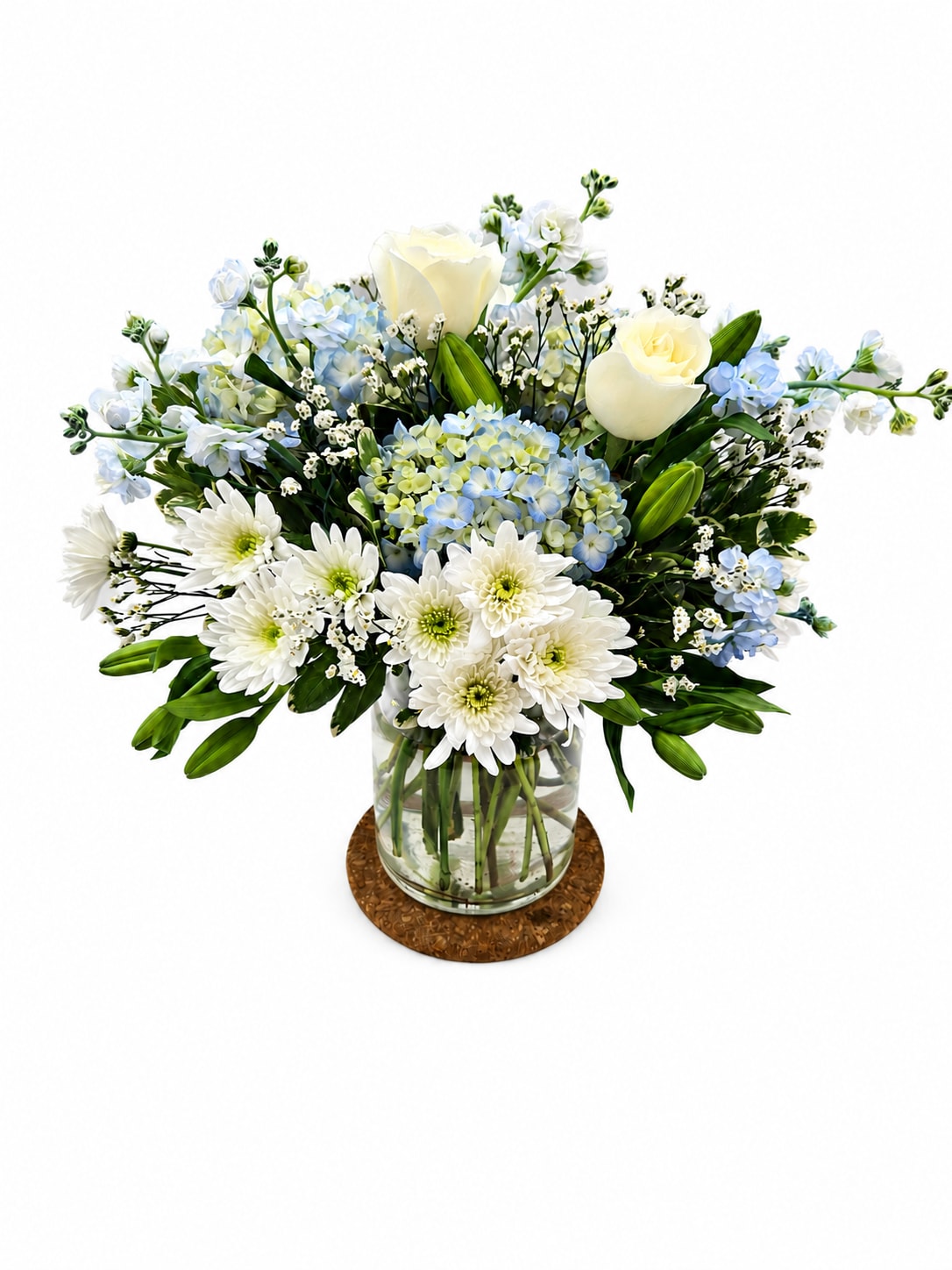 Blue Sky And Sunshine  - Soft blue delphinium spikes rising above a cloud of white roses give this floral arrangement a serene, uplifting presence-perfect as a Mother's Day bouquet or a thoughtful birthday surprise. The flower arrangement pairs pale blue hydrangea-like blooms and airy lisianthus with layered white roses, creating a calm, elegant palette that feels both fresh and refined for everyday gifting.  Arranged in a clear glass vase and finished with a light ribbon, the composition is full and rounded yet airy, with silvery-green foliage adding subtle contrast and texture. Expect a lush, polished look that reads as relaxed sophistication; it's the kind of bouquet that makes the person you're thinking of feel truly seen and cared for without being over the top. Standard vase dimensions and simple care-fresh water and a cool spot away from direct sun-will help the blooms stay beautiful through the week.