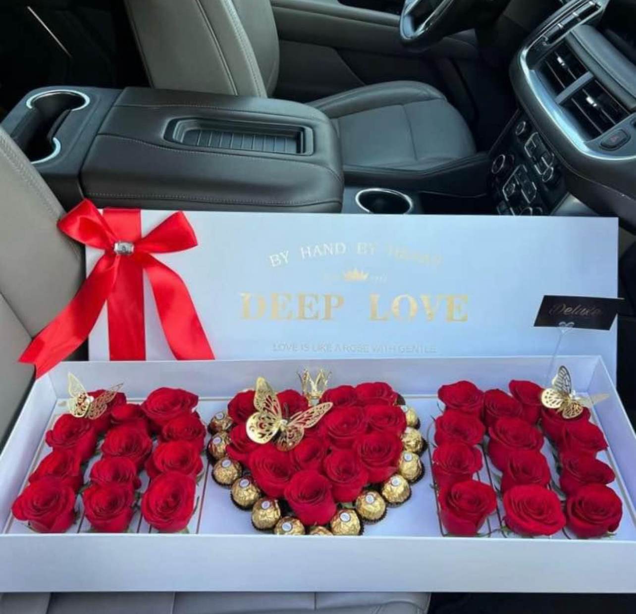 Red roses and chocolates arranged in a gift box with a ribbon