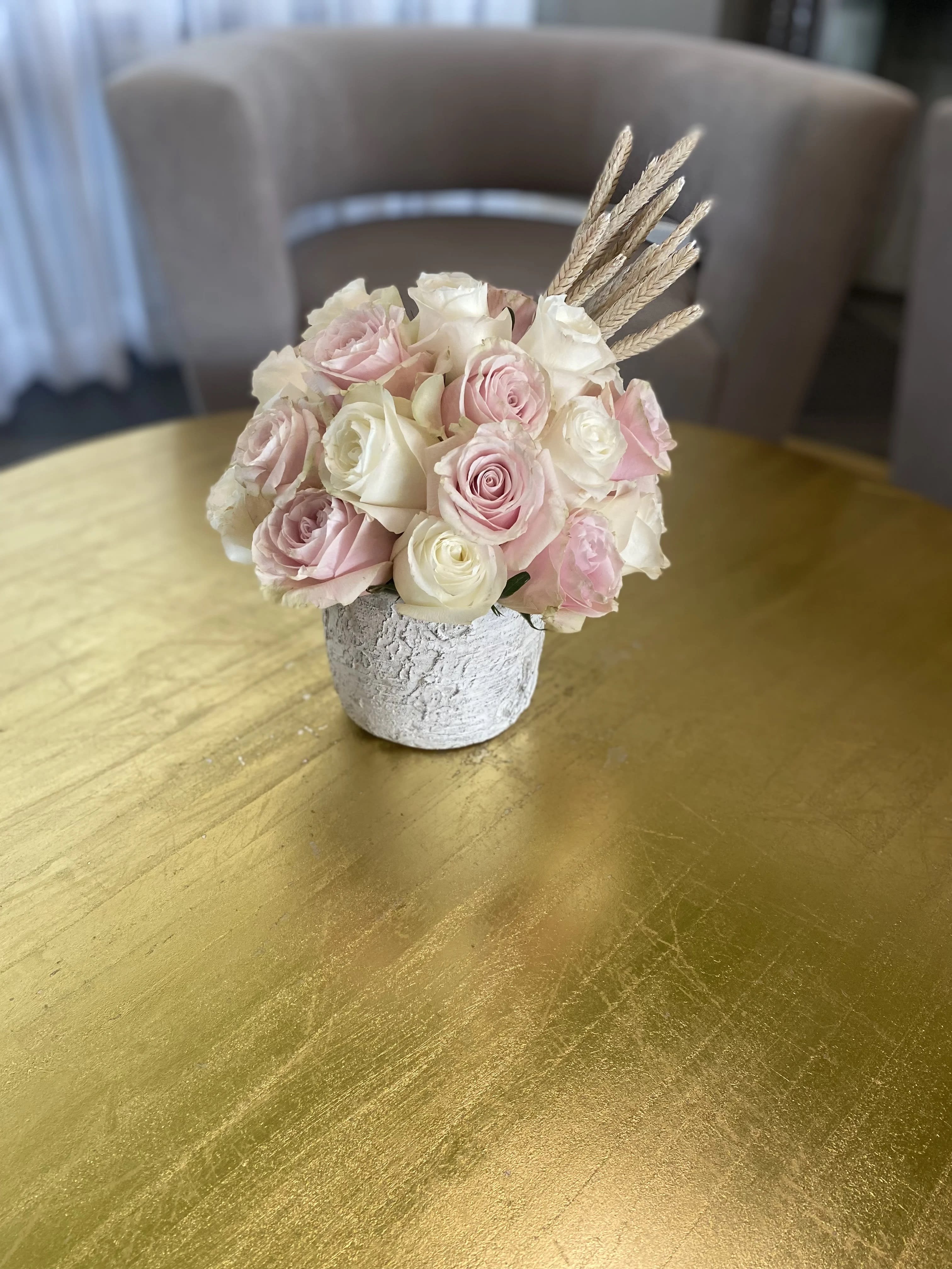 Pink and white rose bouquet in a small textured vase