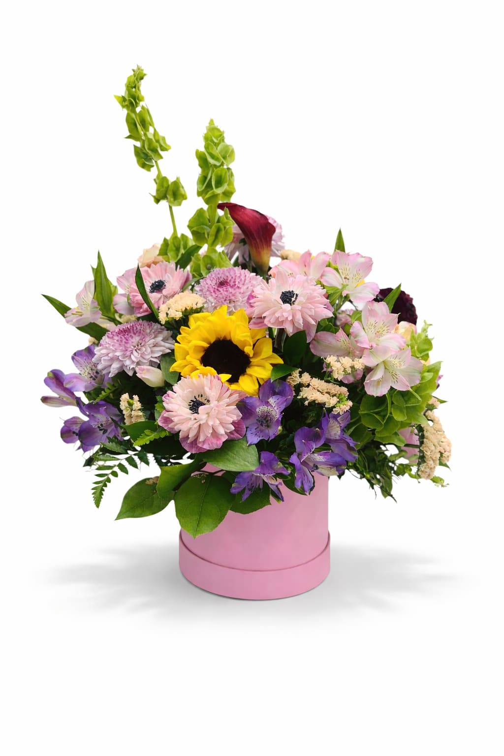 Mixed bouquet in a pink round box with a sunflower and pastel blooms