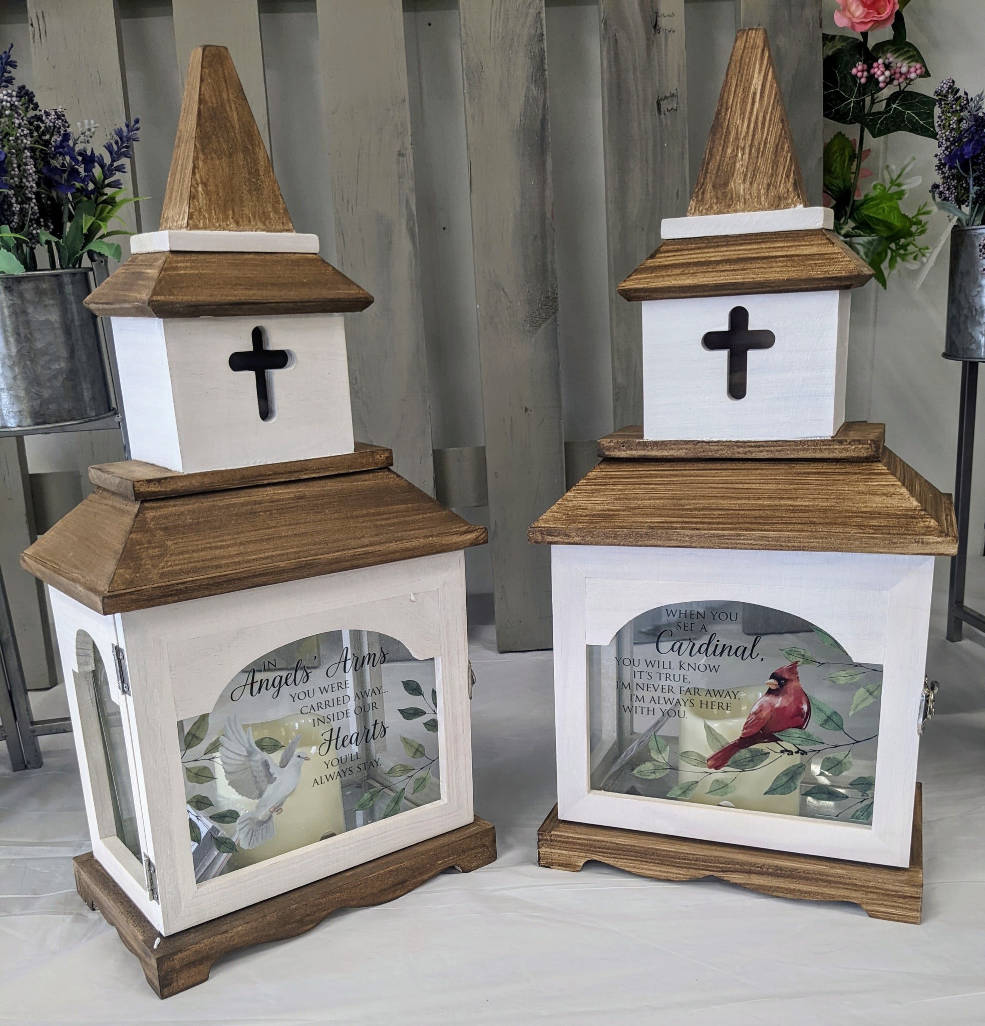 Two wooden memorial lanterns with cross cutouts and printed bird designs