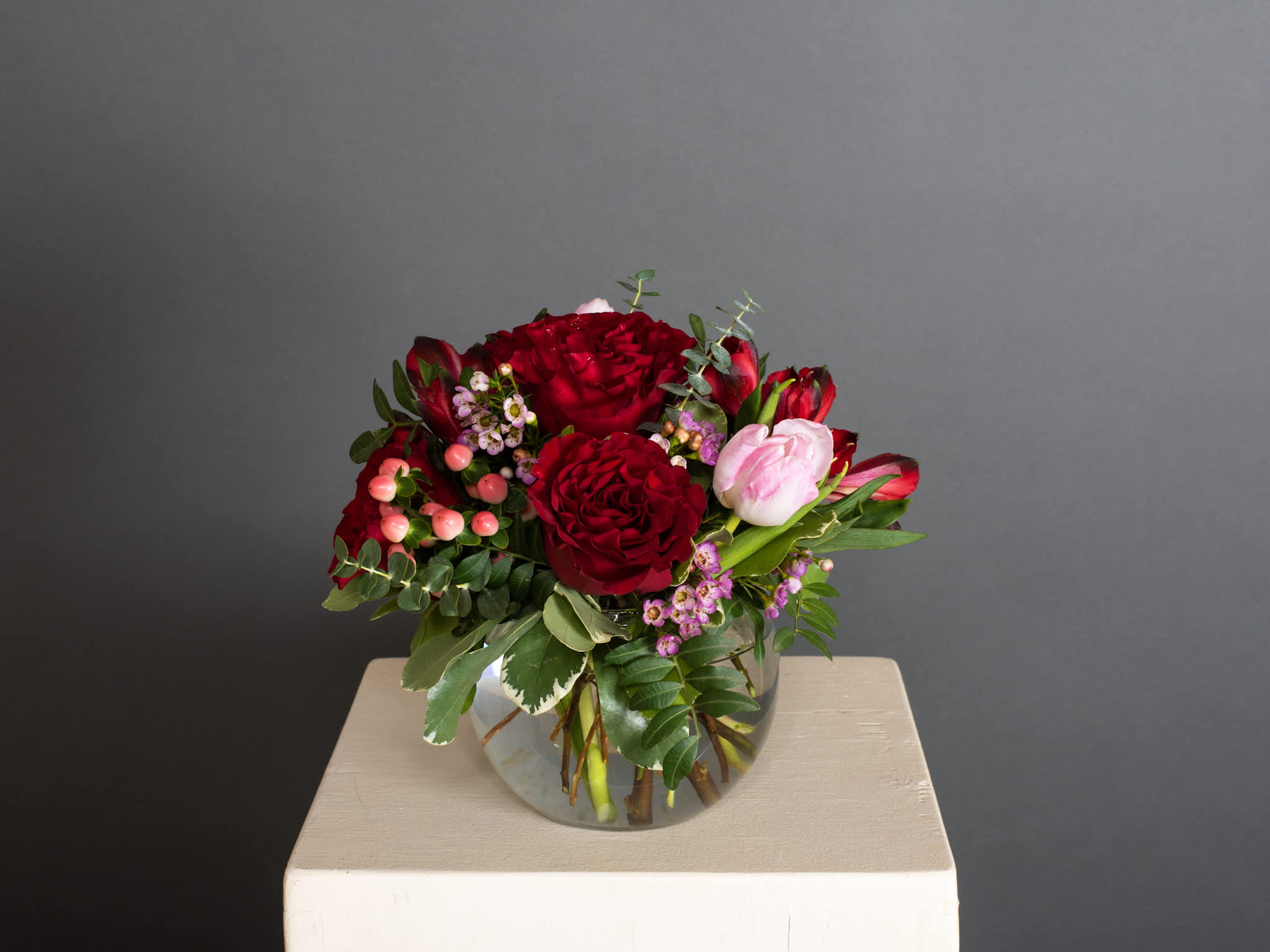 Red and pink flower arrangement in a clear glass vase
