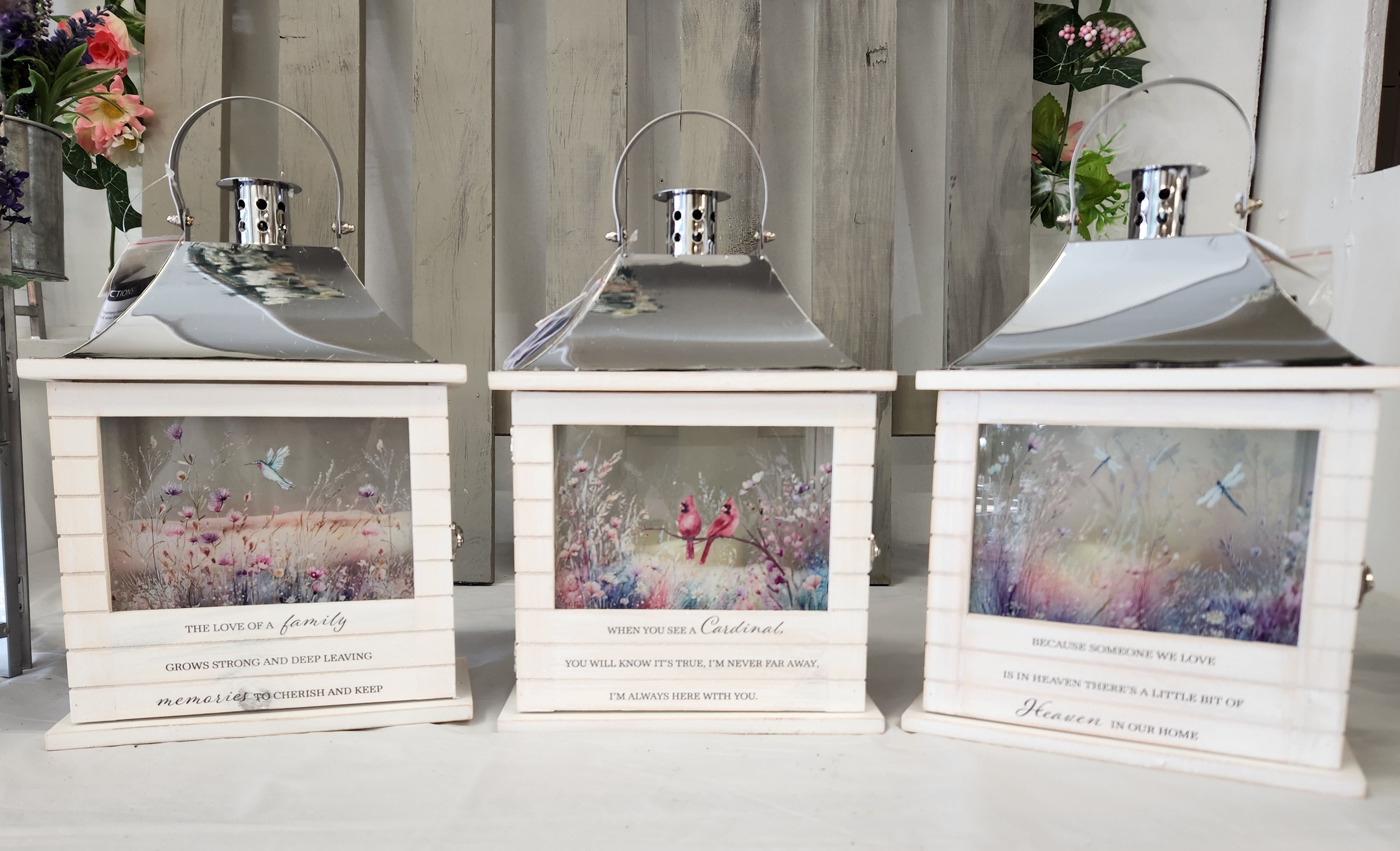 Three white lanterns with printed memorial scenes and quotes