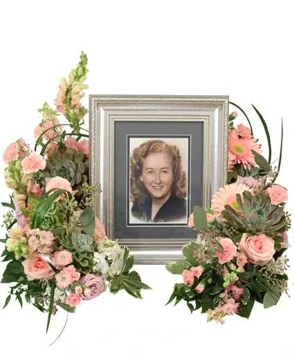 Touching Tranquility Memorial Flowers - Touching Tranquility exudes serene remembrance with succulents, pink larkspur, lavender and pink roses, and hot pink gerberas. Each element blends harmoniously, symbolizing resilience and cherished memories. This arrangement offers comfort and serenity as it honors a beloved life.  Includes: Wreath With Cut Out, Seeded Eucalyptus, Fatsia, Green Lily Grass, Variegated Pittosporum, Italian Ruscus, Succulents, Hot Pink Mini Carnations Light Pink Gerberas Blue Hydrangeas Pink Larkspur Lavender Roses Pink Snapdragons Lavender Stock Pink Roses.