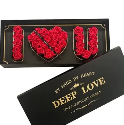 Black gift box with red roses arranged to spell I heart U