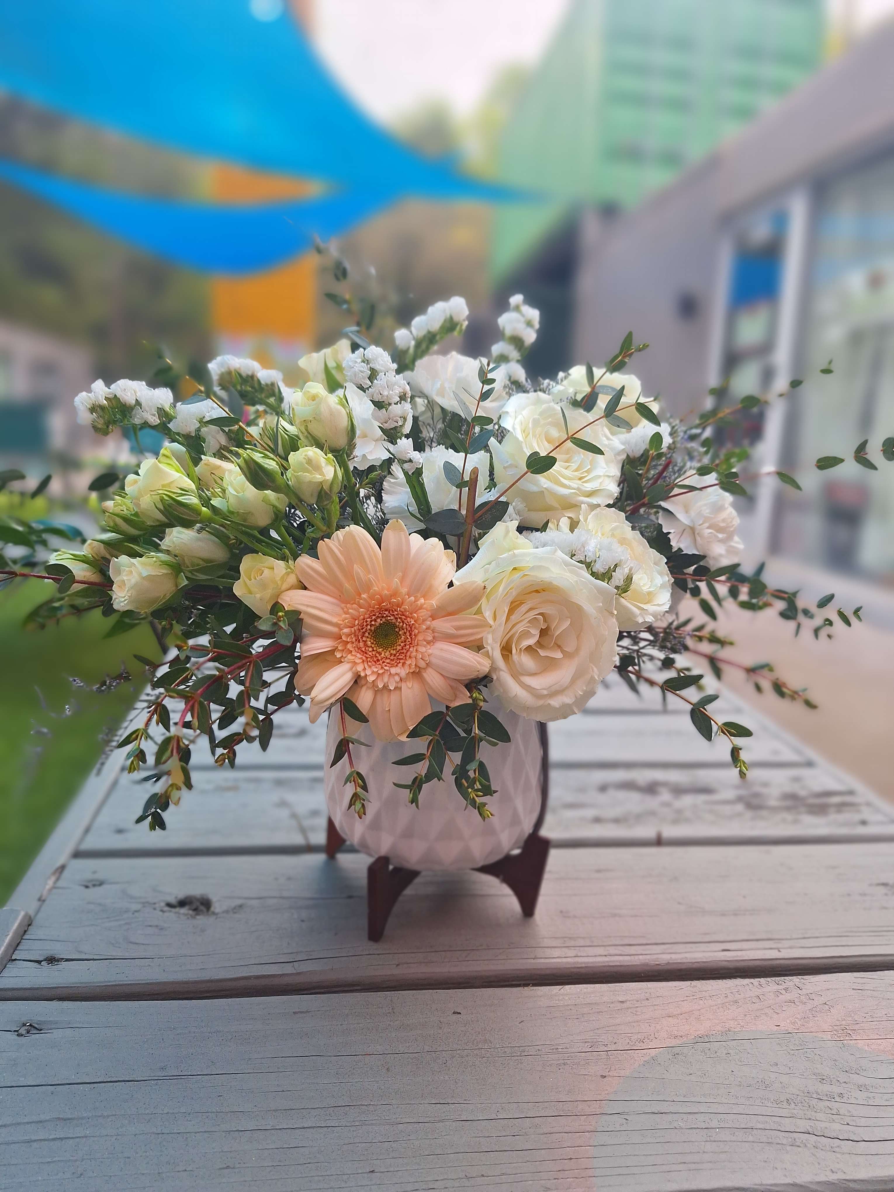 Peach gerbera and white roses in a pink vase
